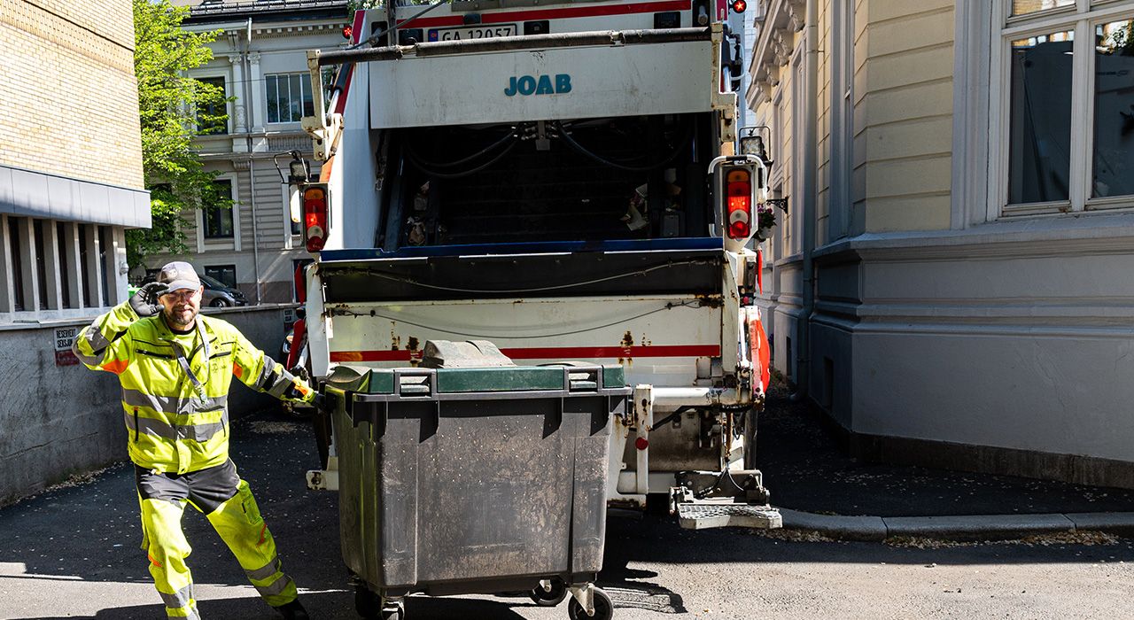 En renovasjonsmedarbeider henter avfall.