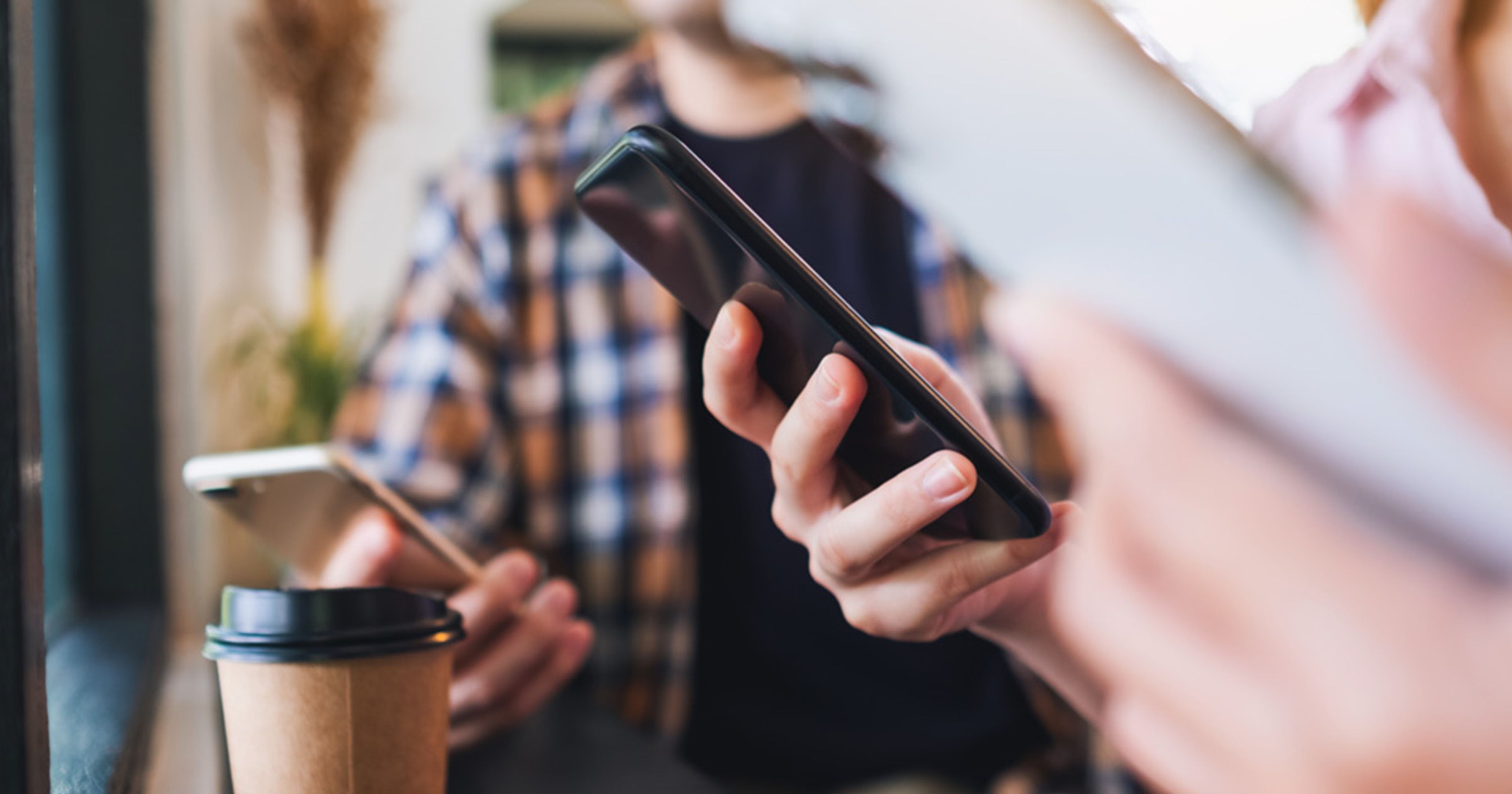 To mennesker holder hver sin mobiltelefon