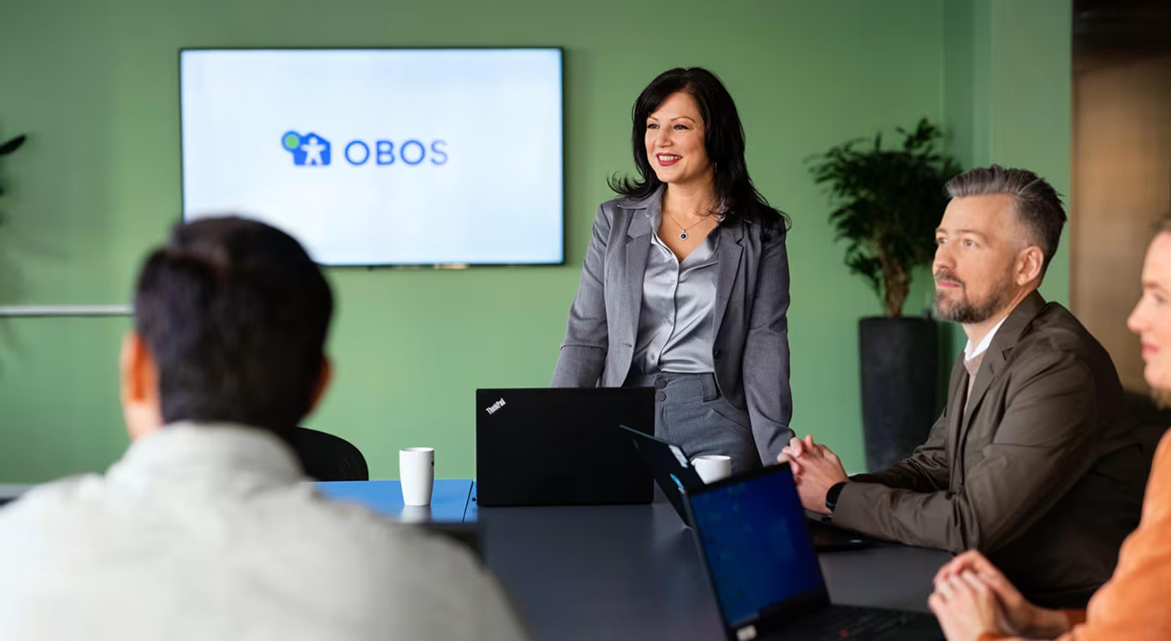 Fire personer sitter i et møterom på OBOS.