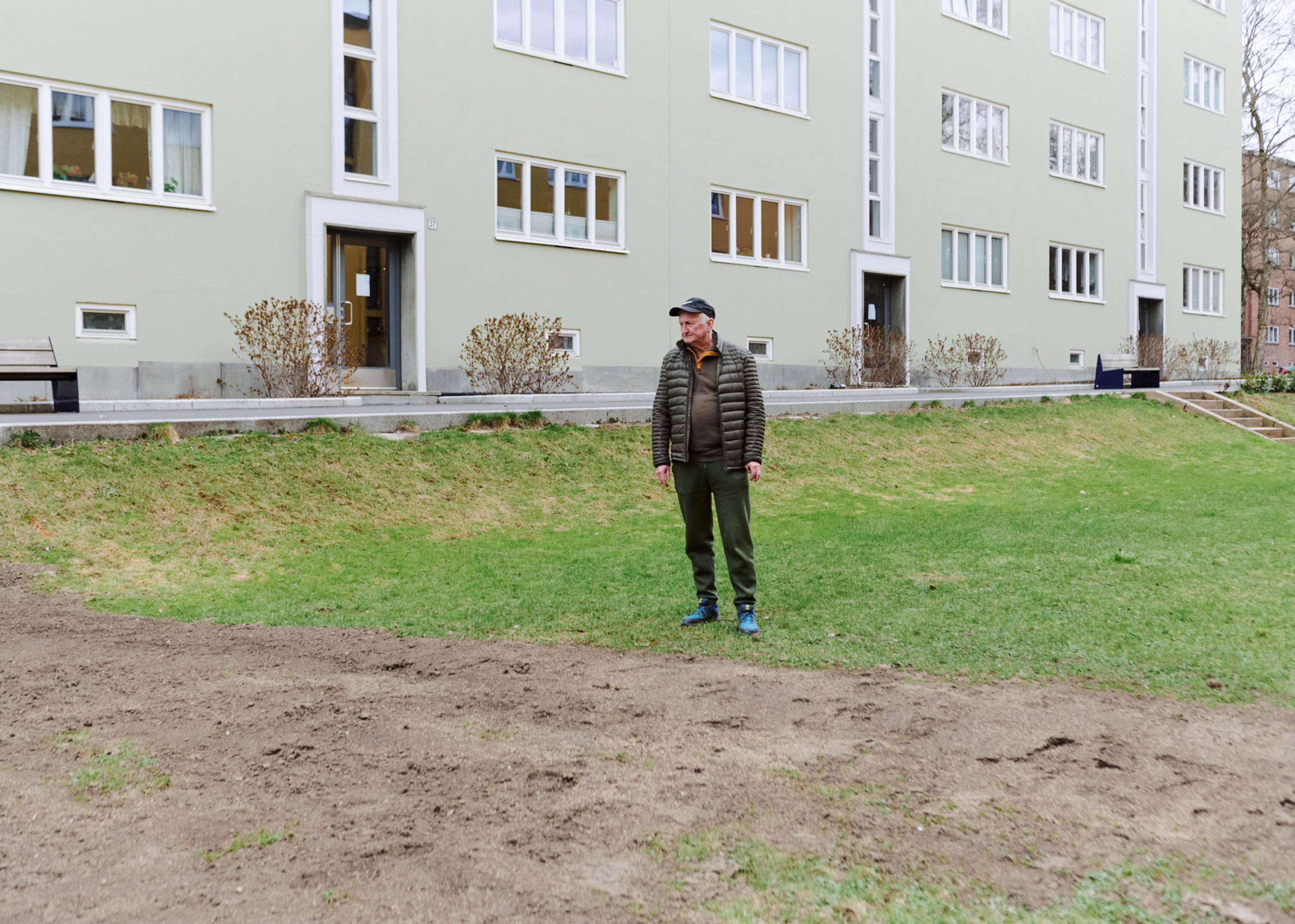 Foto av styreleder Bjørn Berg foran en av blokkene i borettslaget.