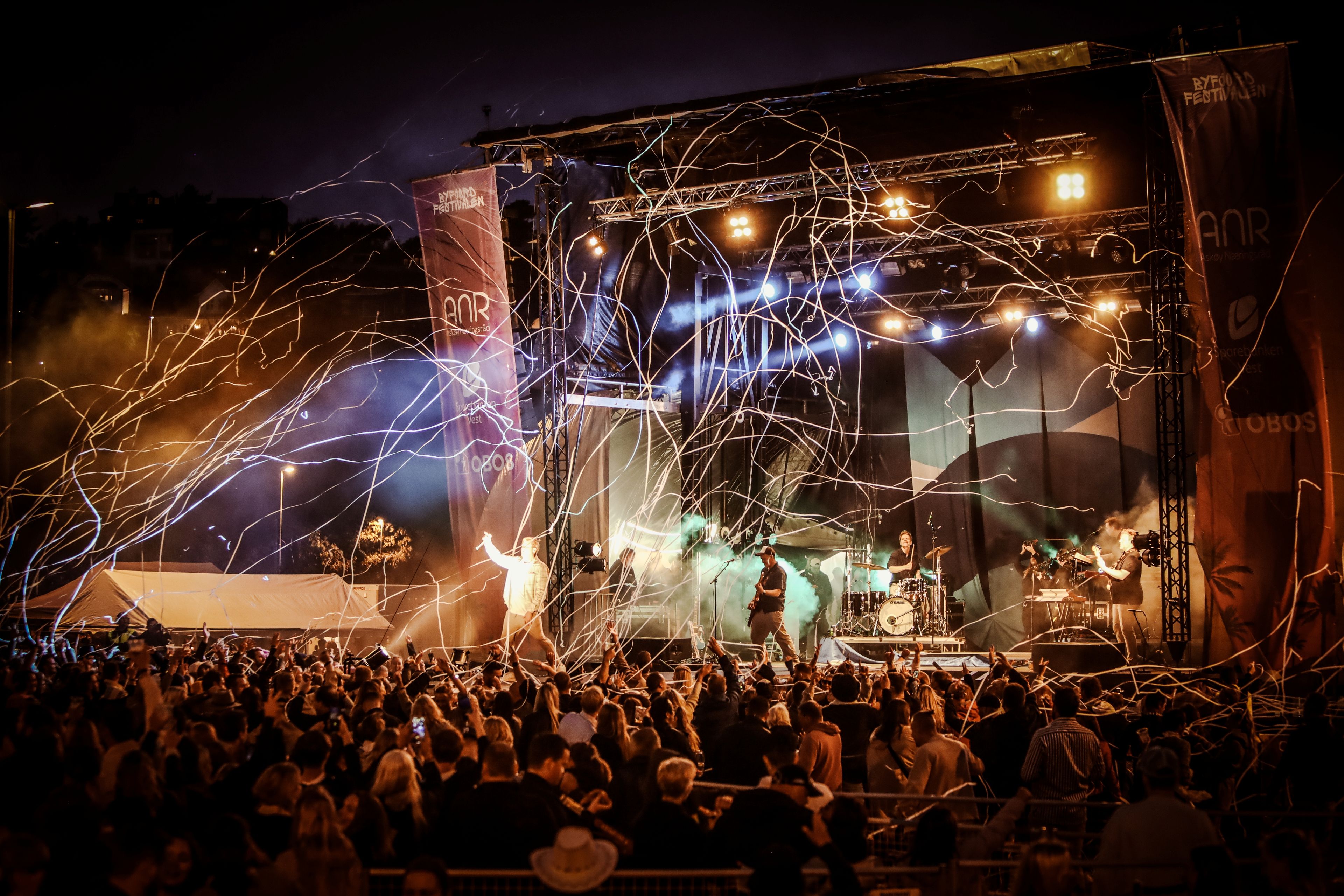 Foto av scenen under Byfjordfestivalen med jublende publikum.