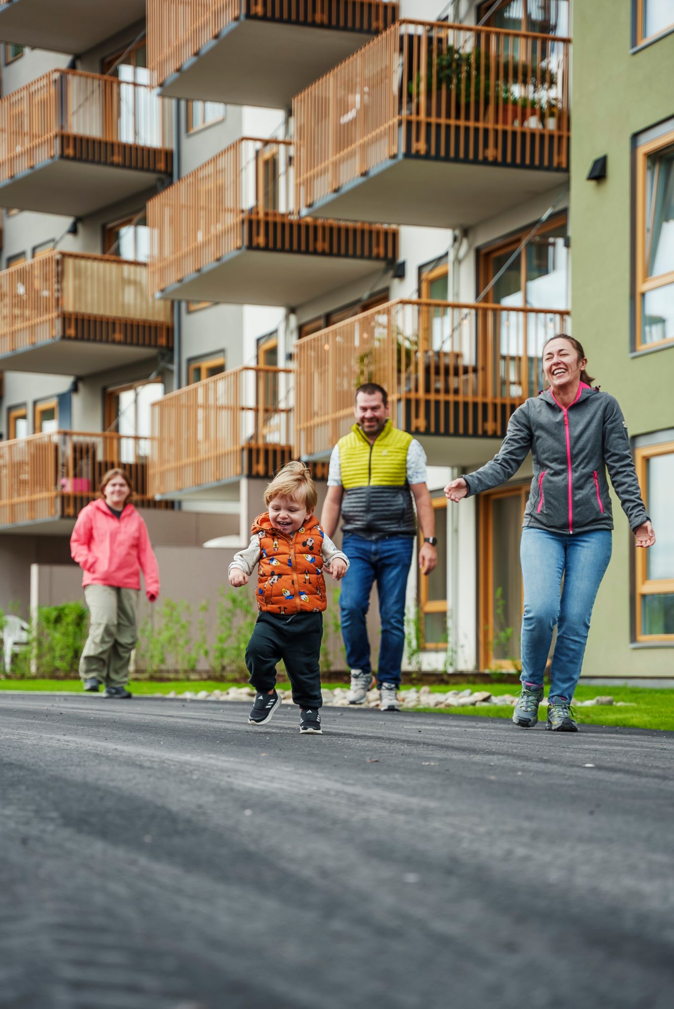 Den vesle familien løper og leker ute mellom blokkene i Asper Hageby.