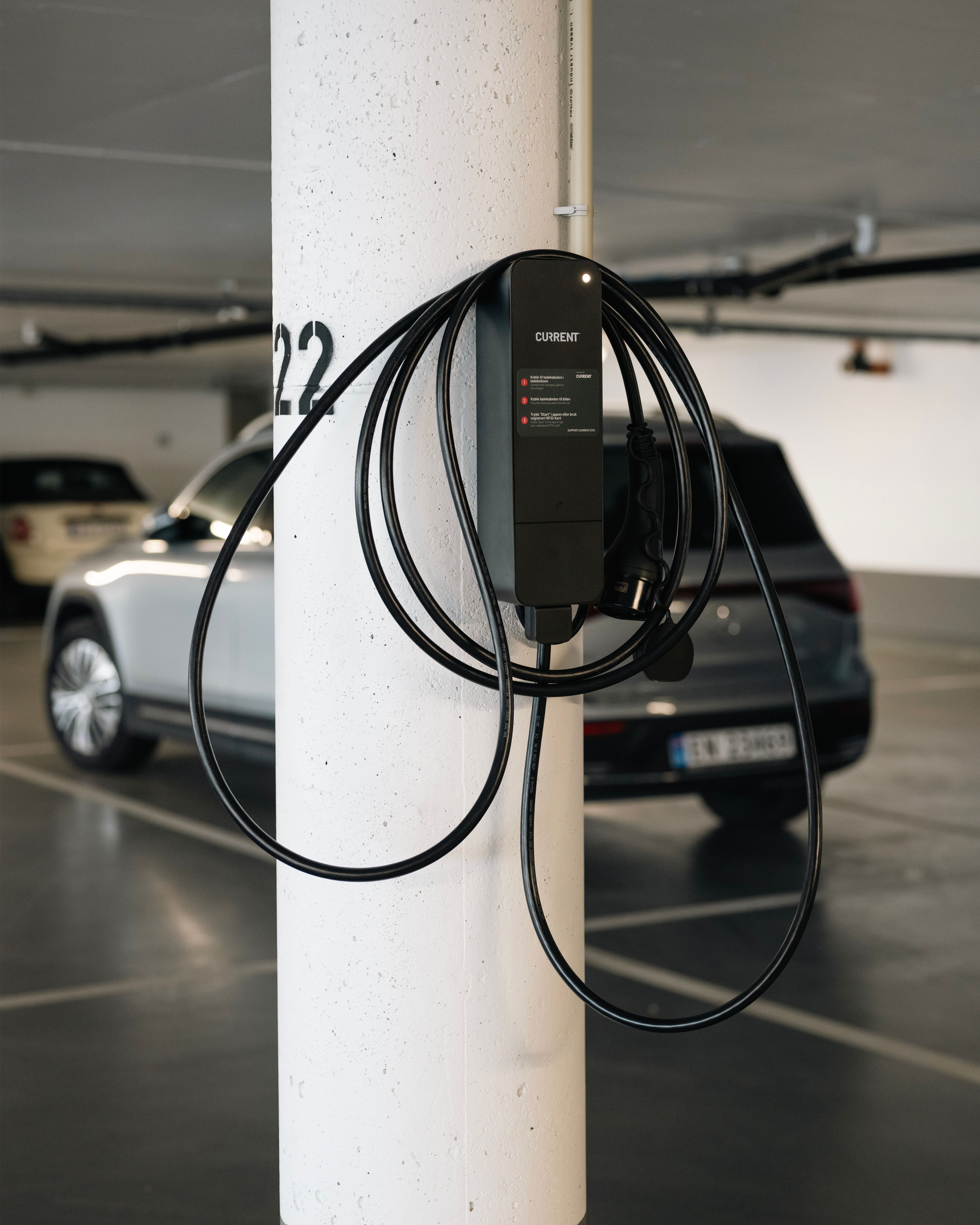 Ladekabel som henger på pullert i parkeringshuset.