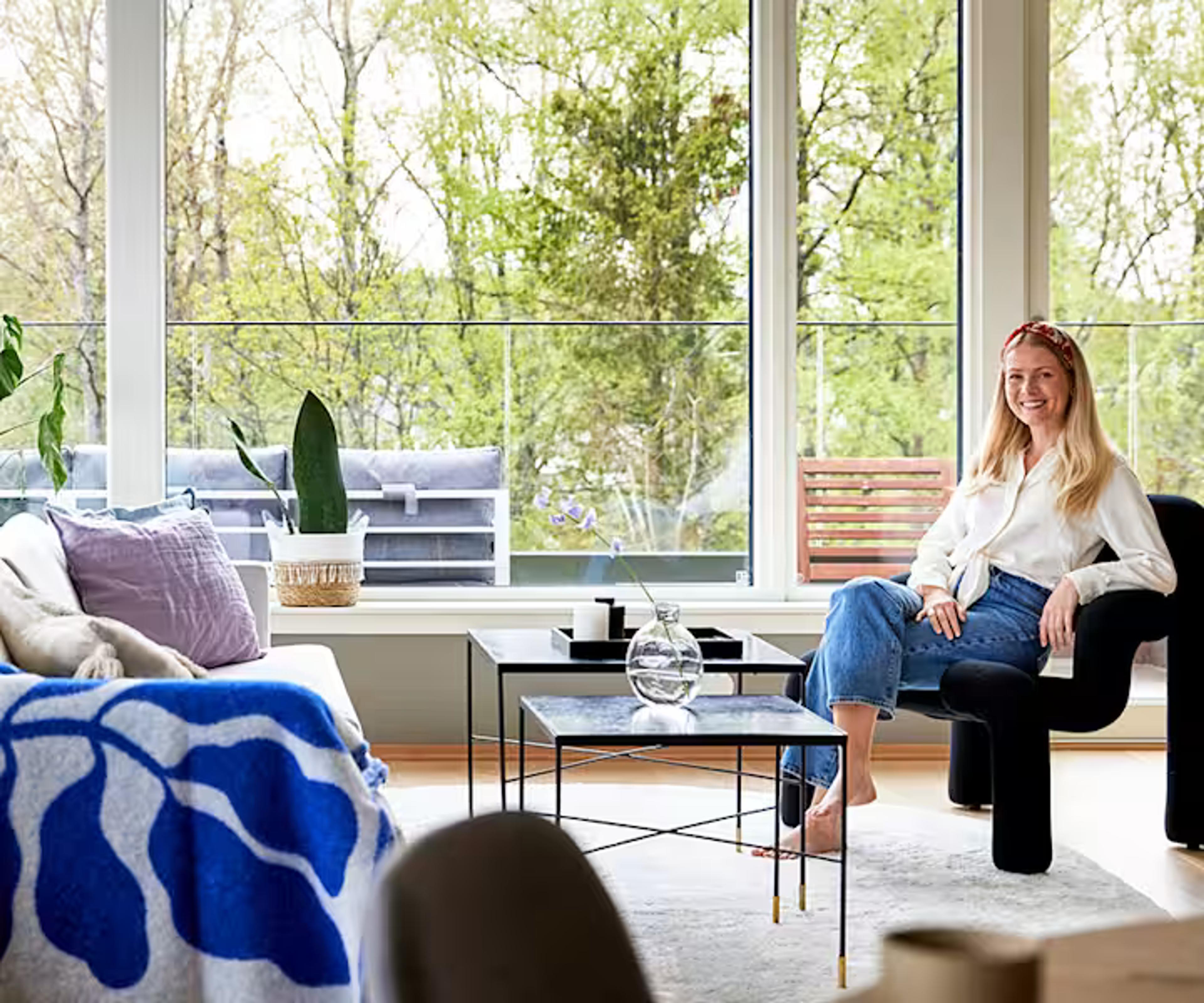 Foto av stuen hjemme hos Ane i Solon-bolig i Ski. Ane sitter i en stol.