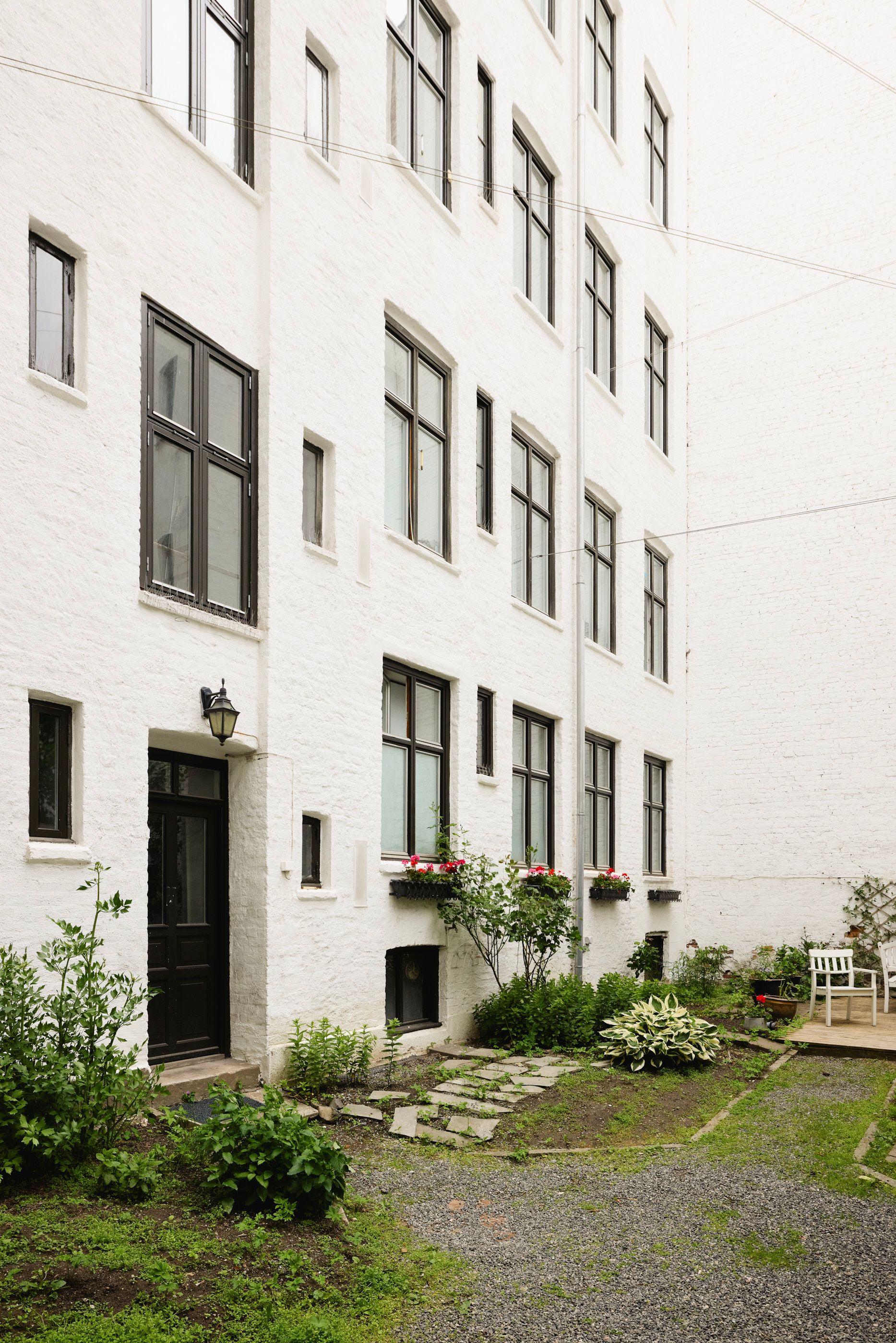 Inngangspartiet til en hvit boligblokk.