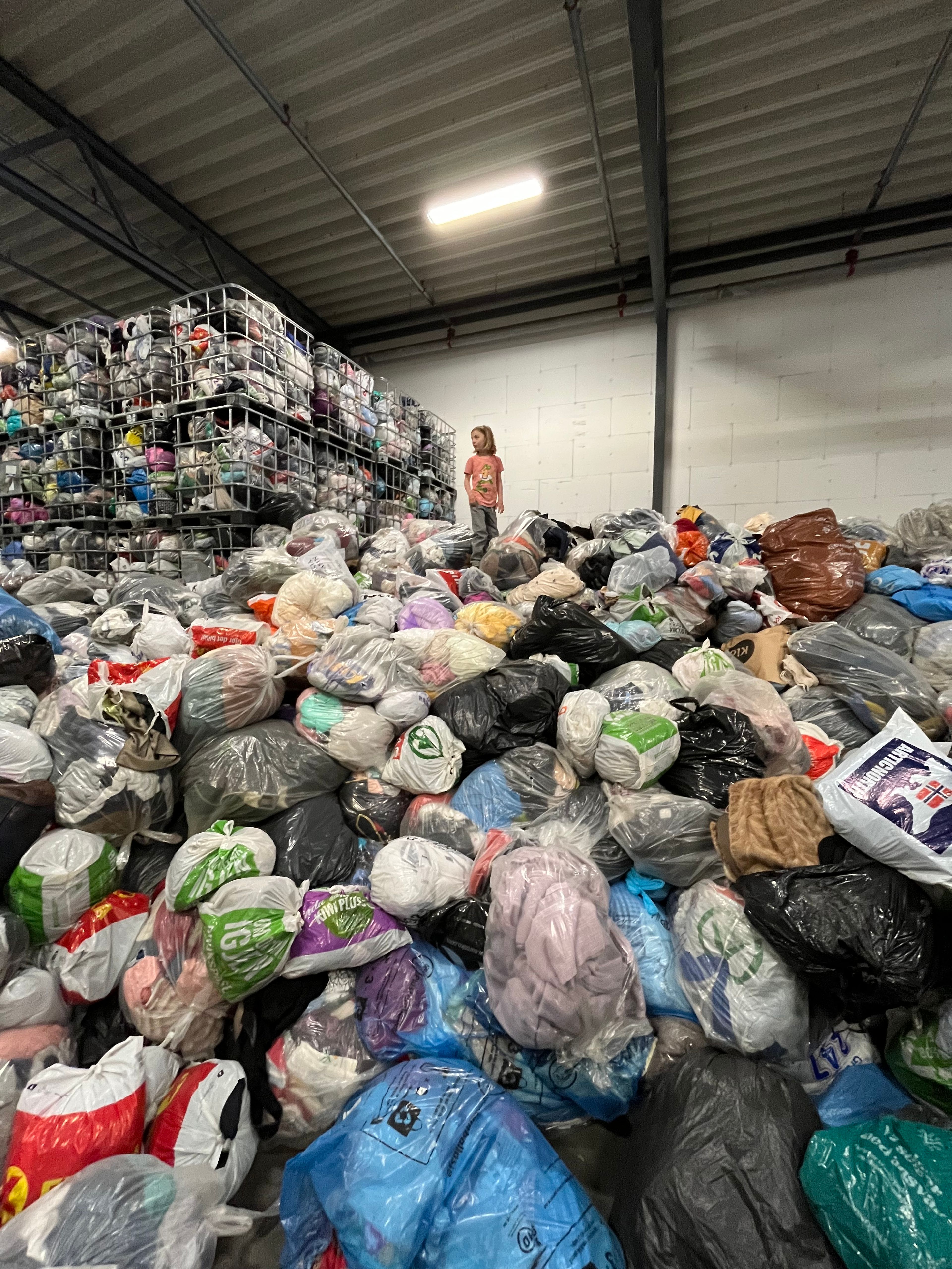 Lagerhall hos Kirkens Bymisjon der gulvet er dekket av sekker med brukte klær.
