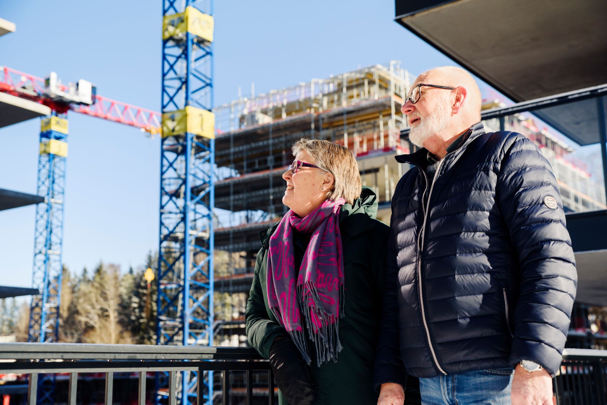 Foto av et par som står å titter opp på noen heisekraner.