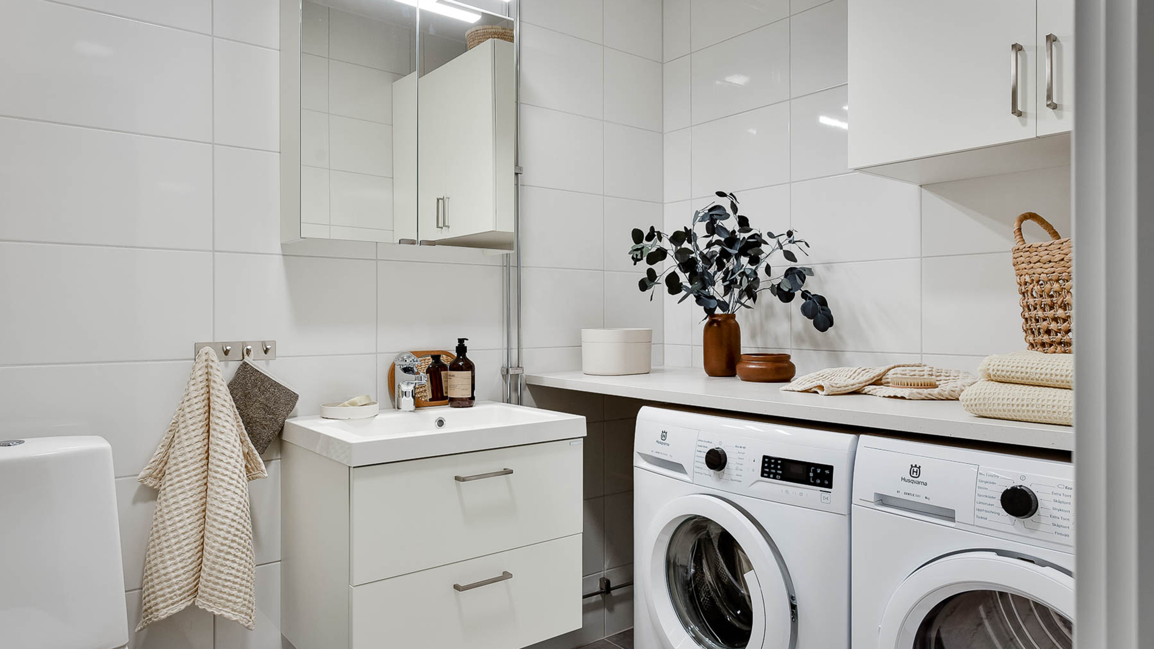 Rymligt badrum med tvättmaskin och torktumlare