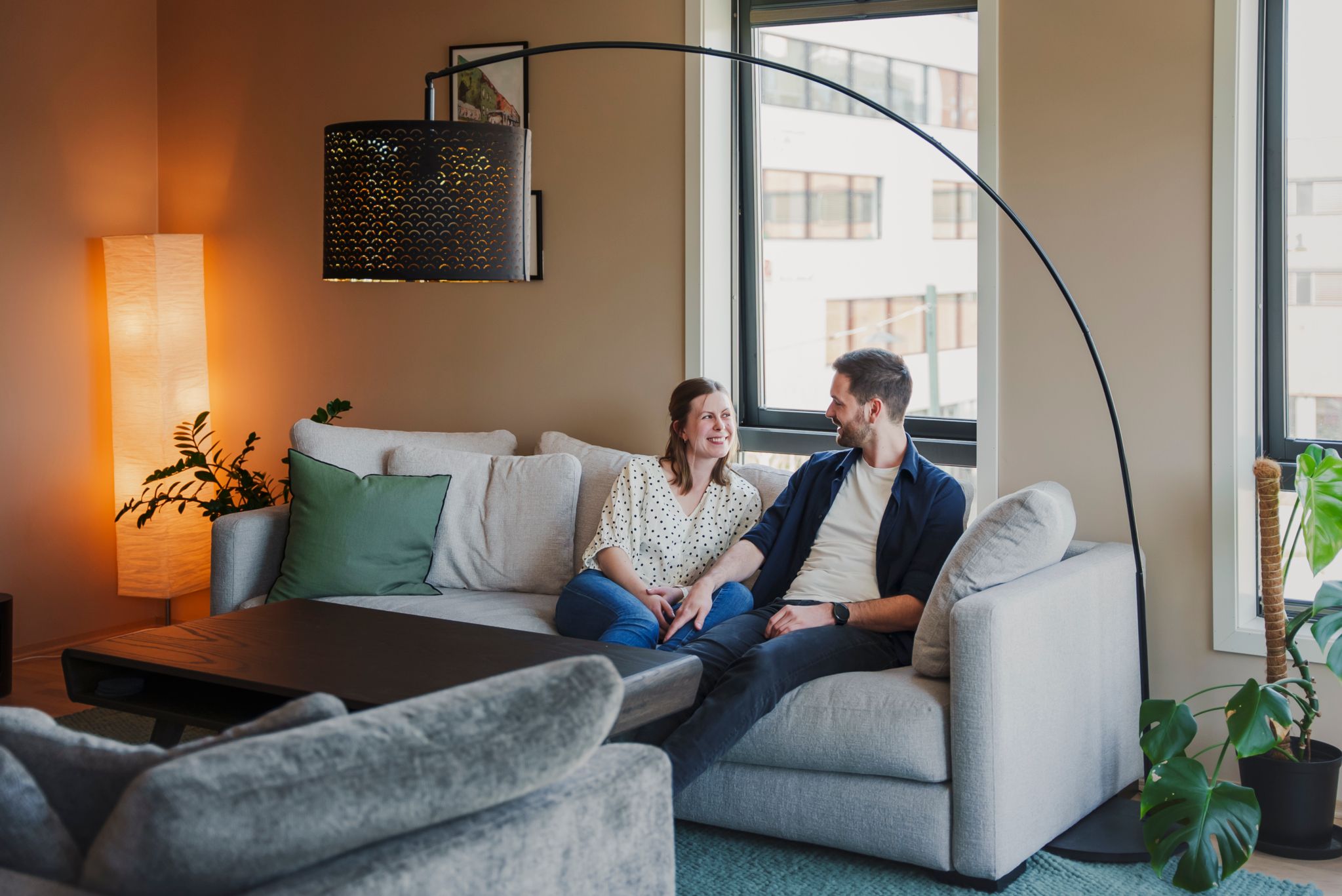 Bilde av et par som sitter i sofaen sin i en leilighet.