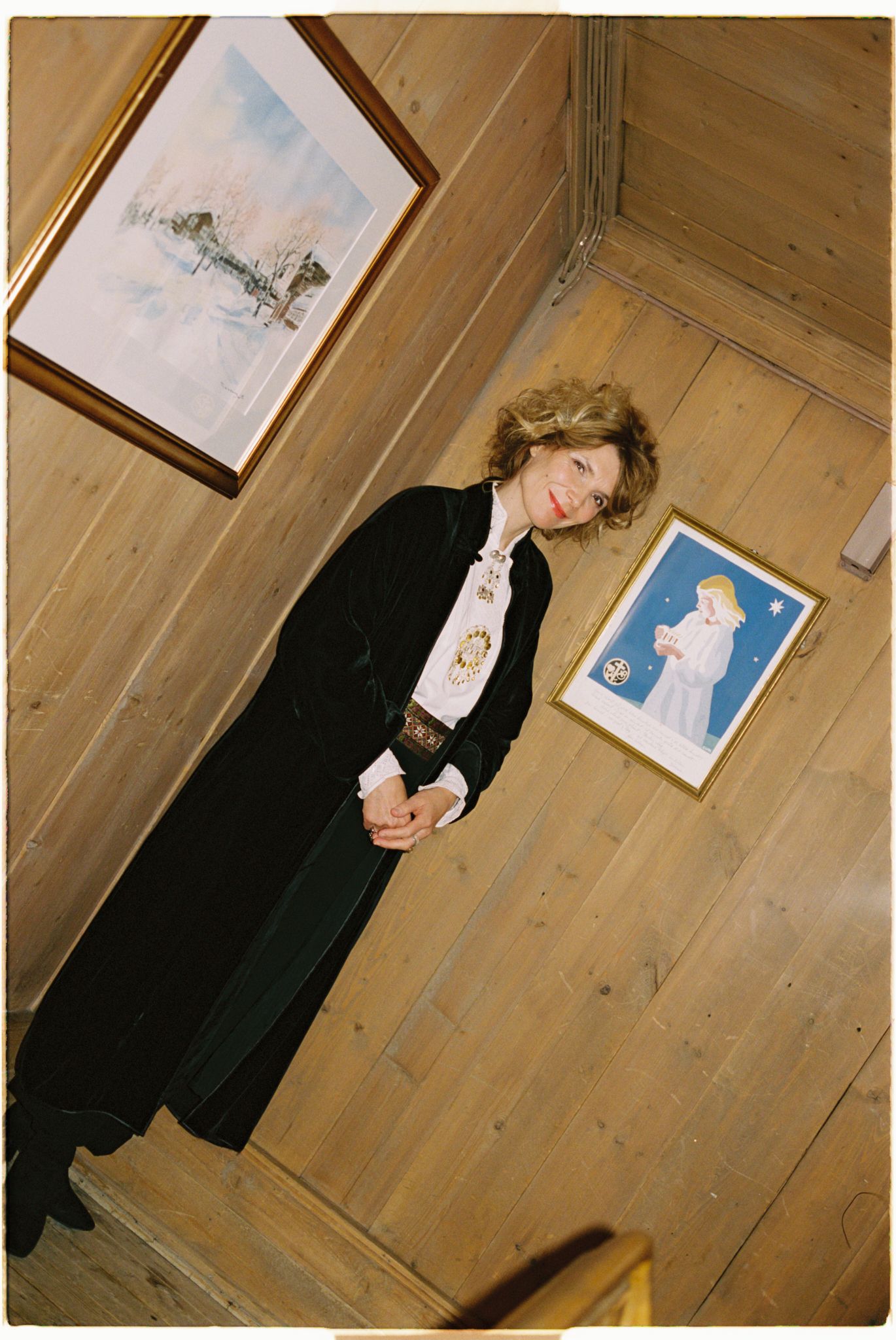 Herborg Kråkvik står inntil en furuvegg iført bunad.