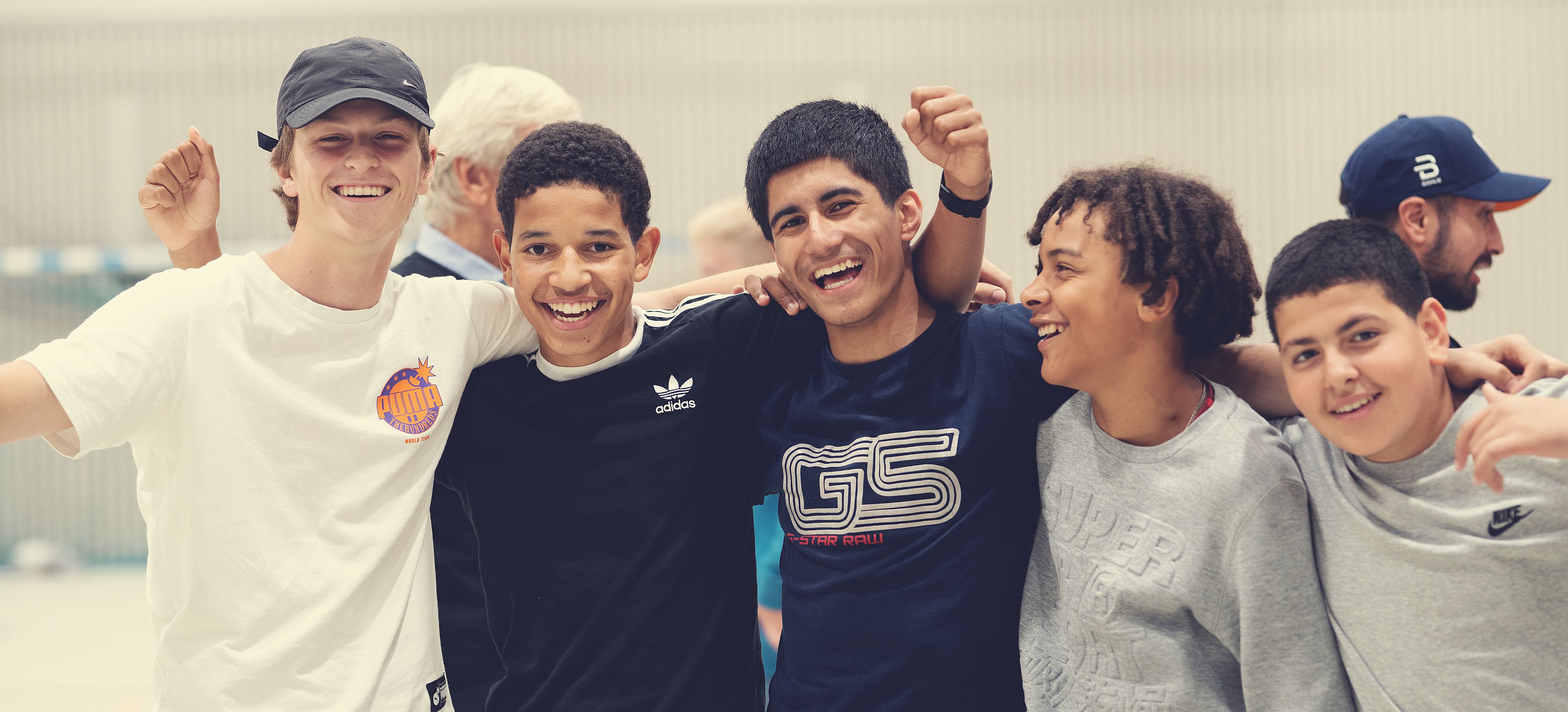 Fem ungdommer smiler til kamera.