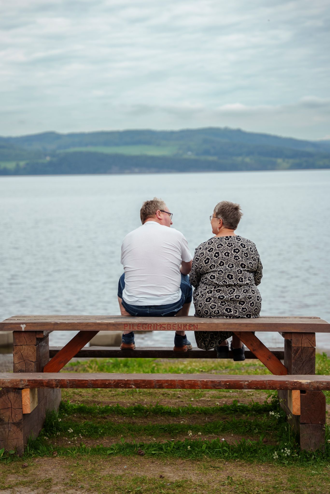 Bilde av Rune Gihlemoen og Ingrid Raasholm som sitter på en benk og ser ut over Mjøsa