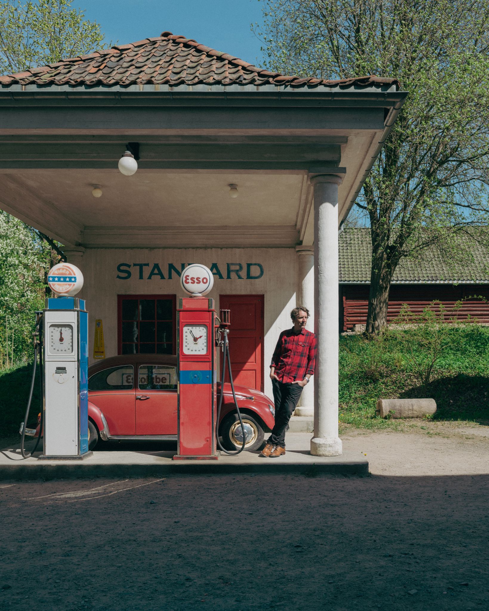 Fotografi av Odd Nordstoga ved en gammel bensinstasjon på Norsk Folkemuseum