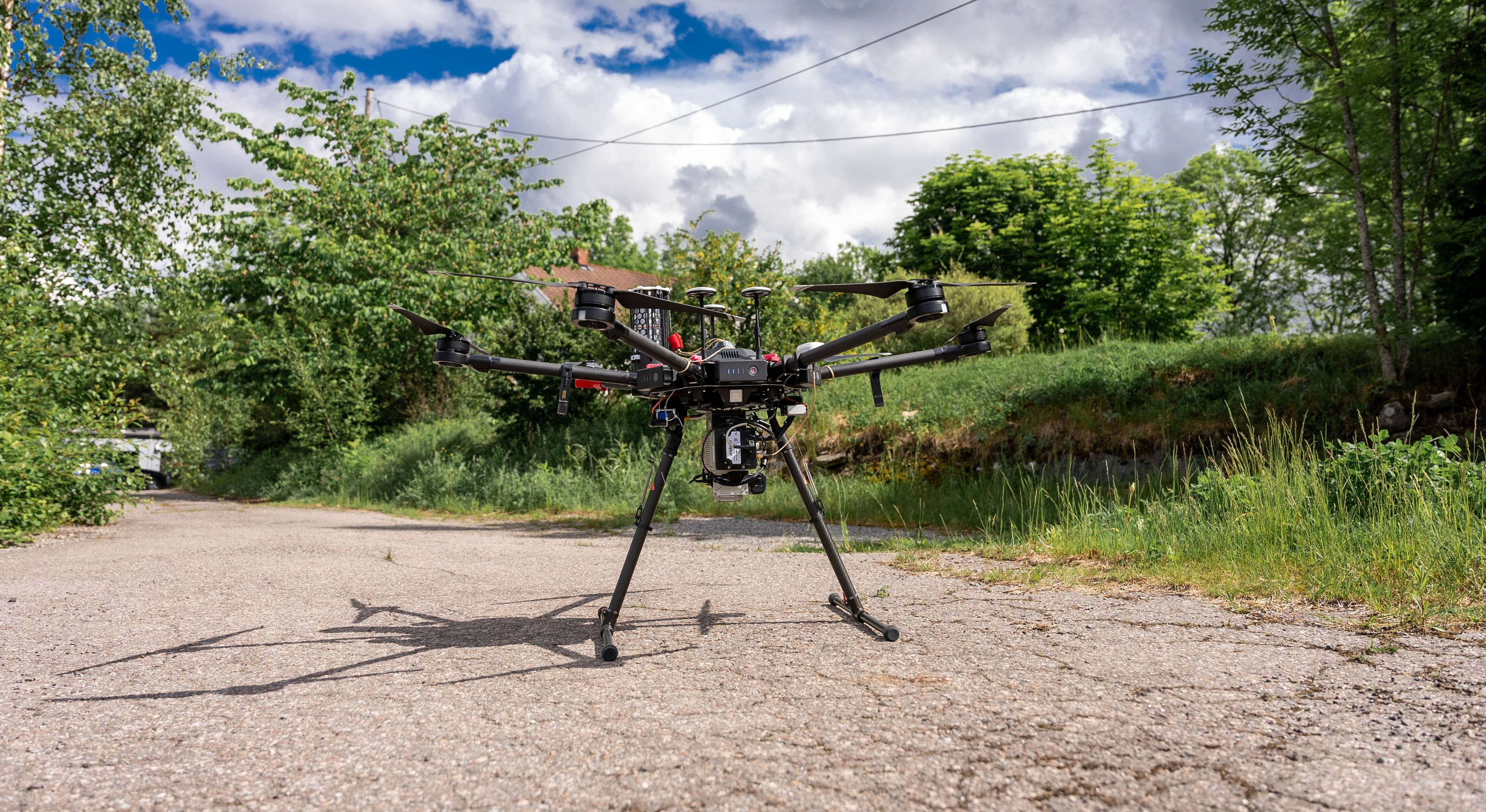 Foto av en drone som står ute på bakken.