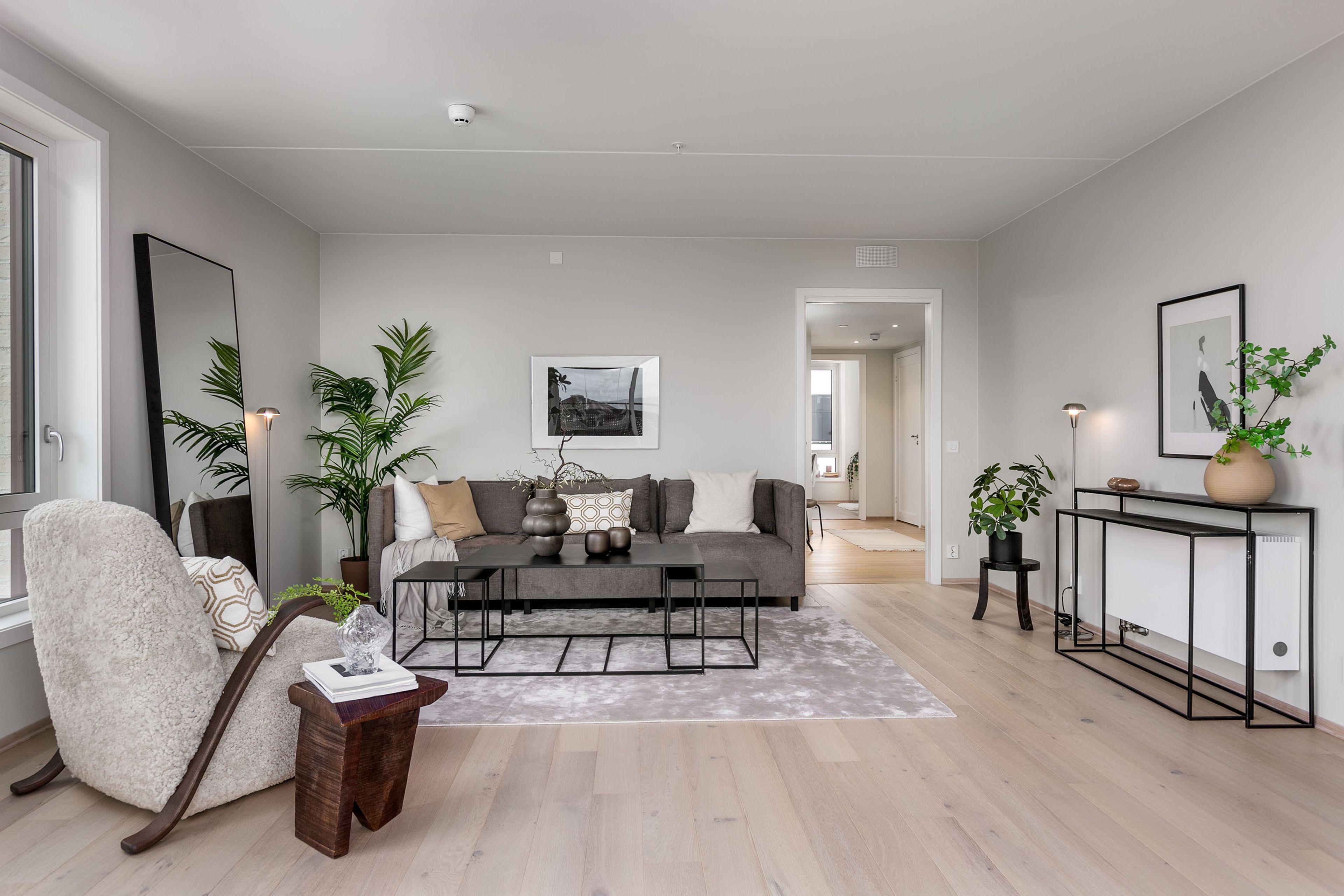 Bilde av sofaområdet i stua. Vinklet slik at man ser gjennom gangen og til soveromsvindu.