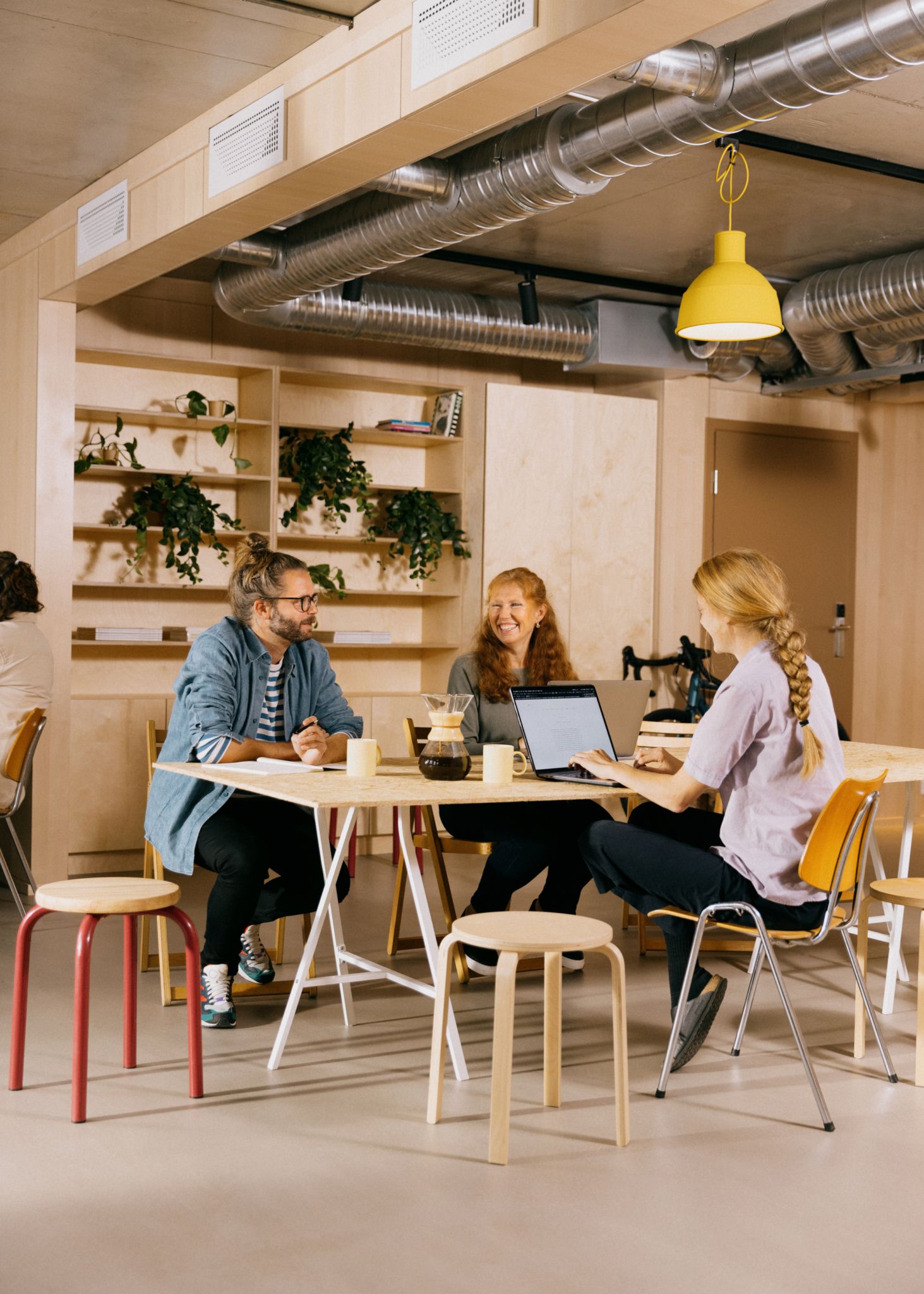 Foto av tre personer som sitter rundt et bord og jobber i OBOS Living Lab
