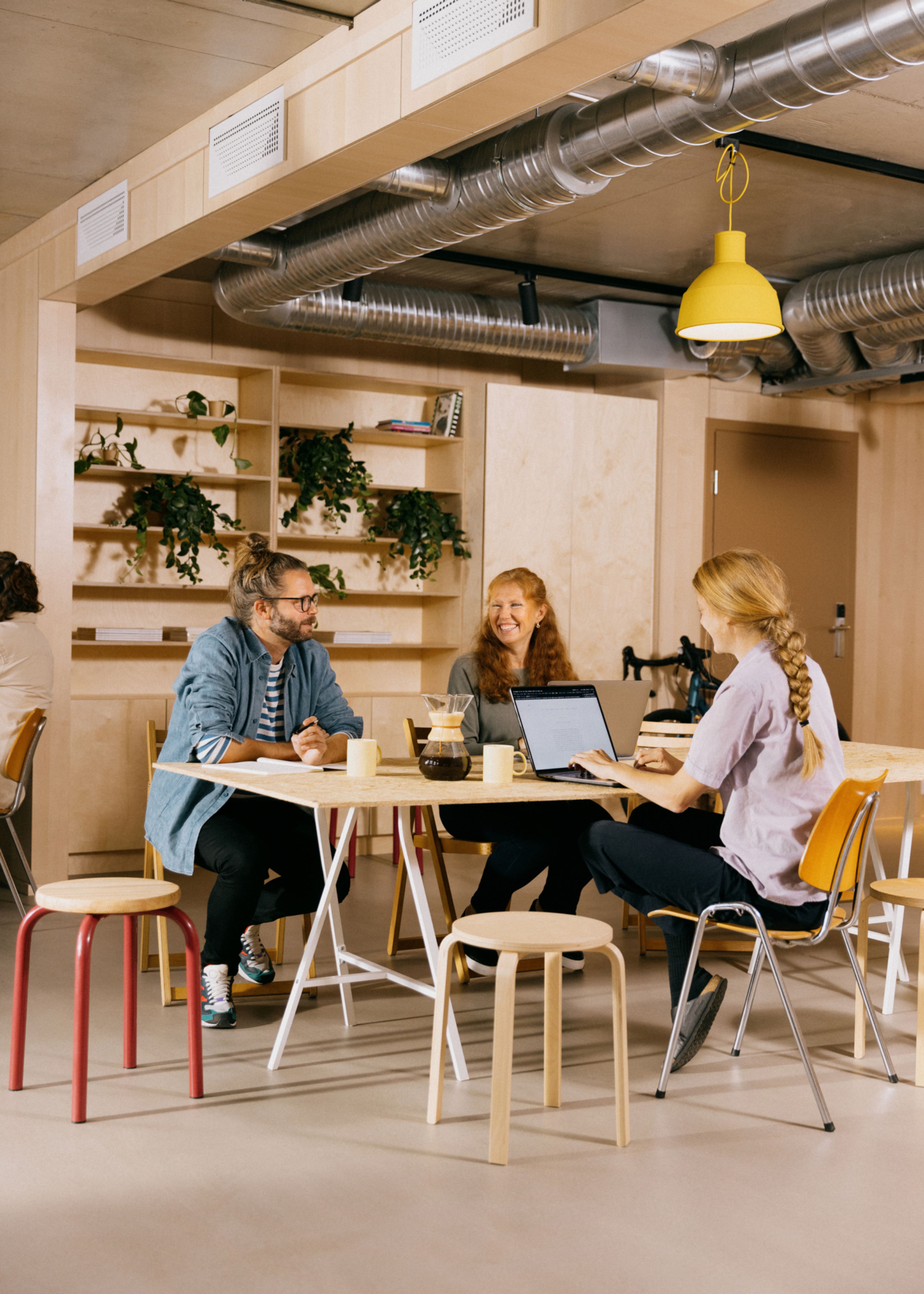 Foto av tre personer som sitter rundt et bord og jobber i OBOS Living Lab
