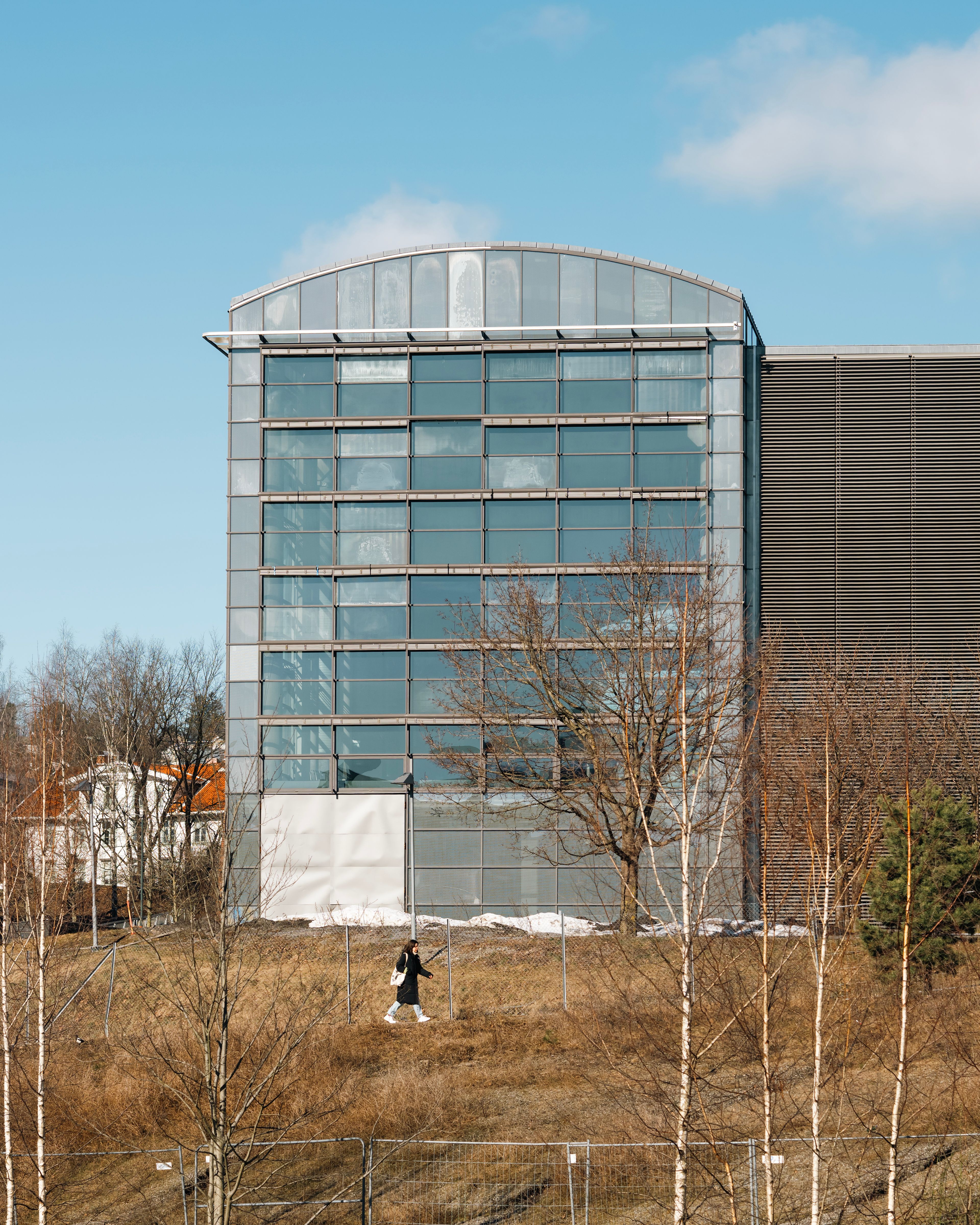 Foto av fasade på en av de gamle trykkerihallene i Nydalen, med bakker i front.
