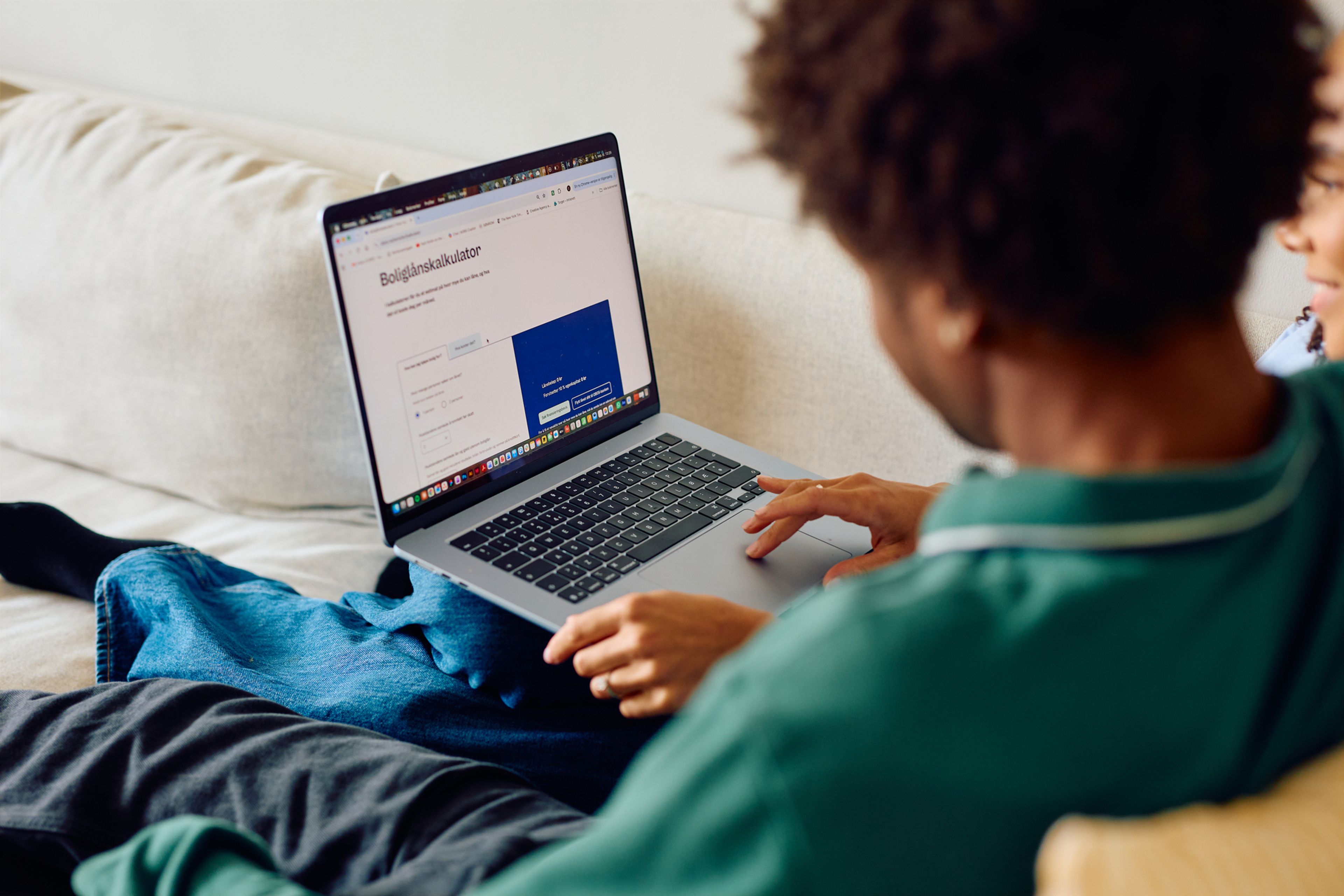 Et vennepar ser på noe på på en laptop sammen.