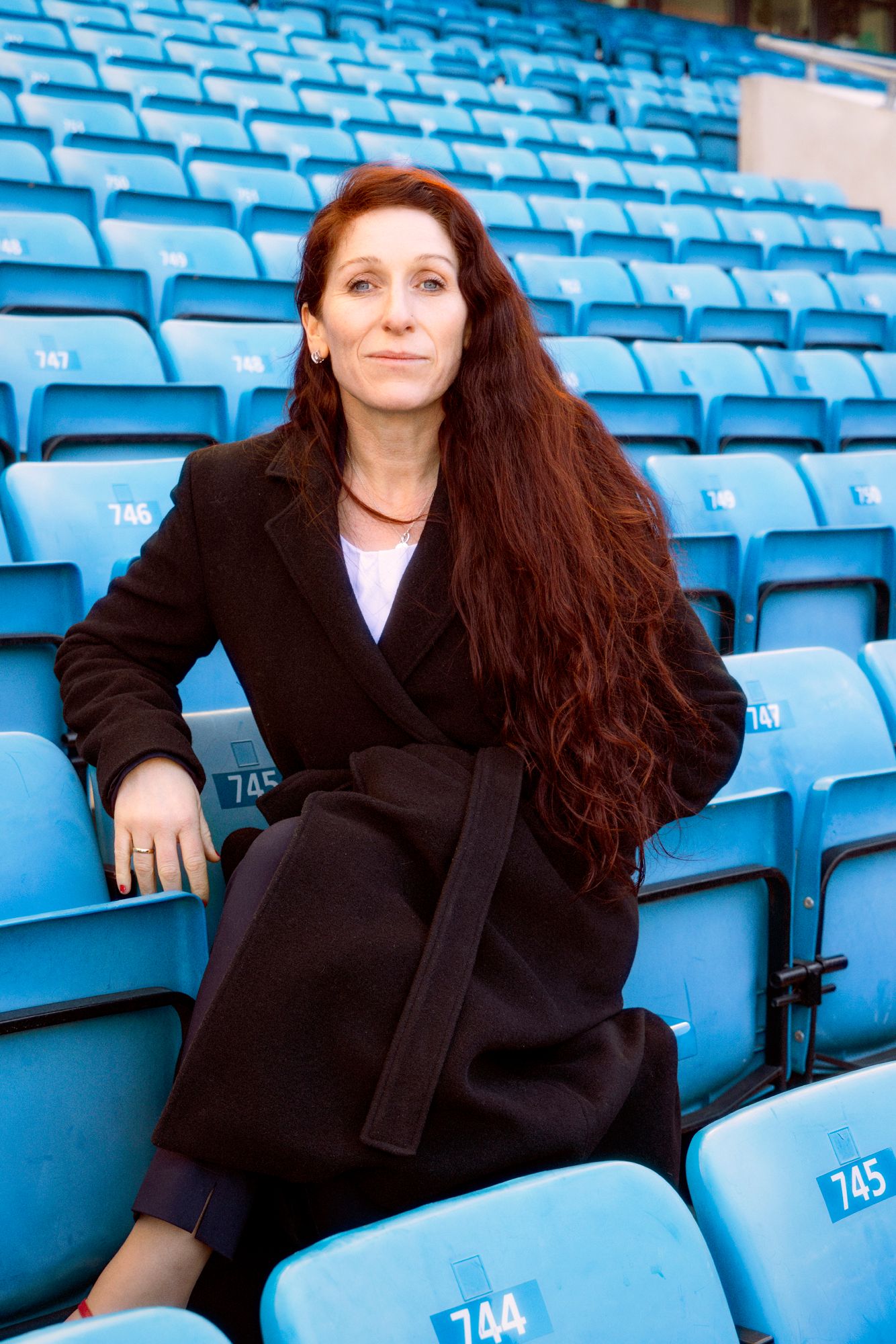 Portrett av Lise Klavenes som sitter på en av de blå tribunestolene på Ullevaal Stadion.