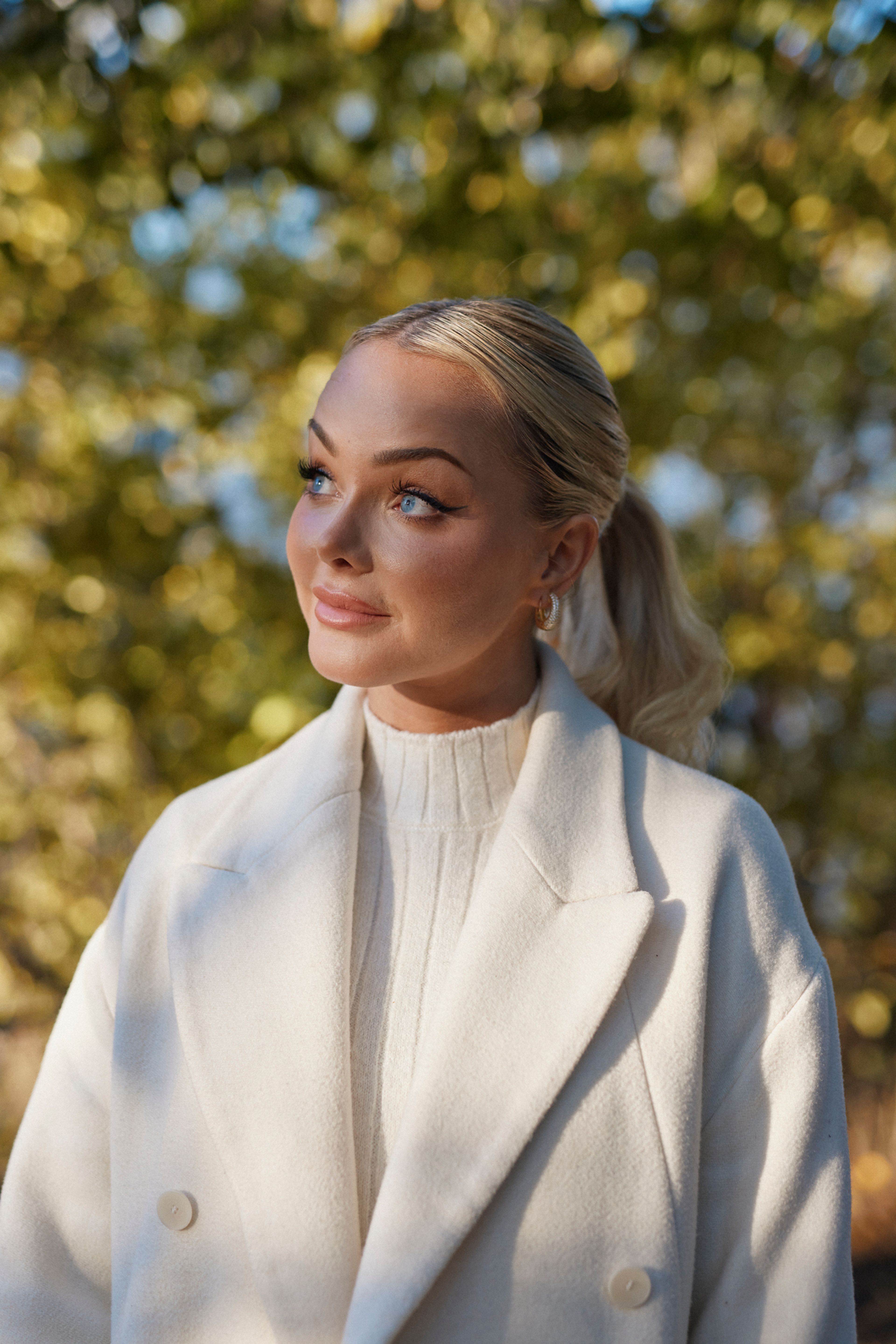 Portrett av Sophie Elise utendørs, i kledd hvit kjole og hvit jakke.