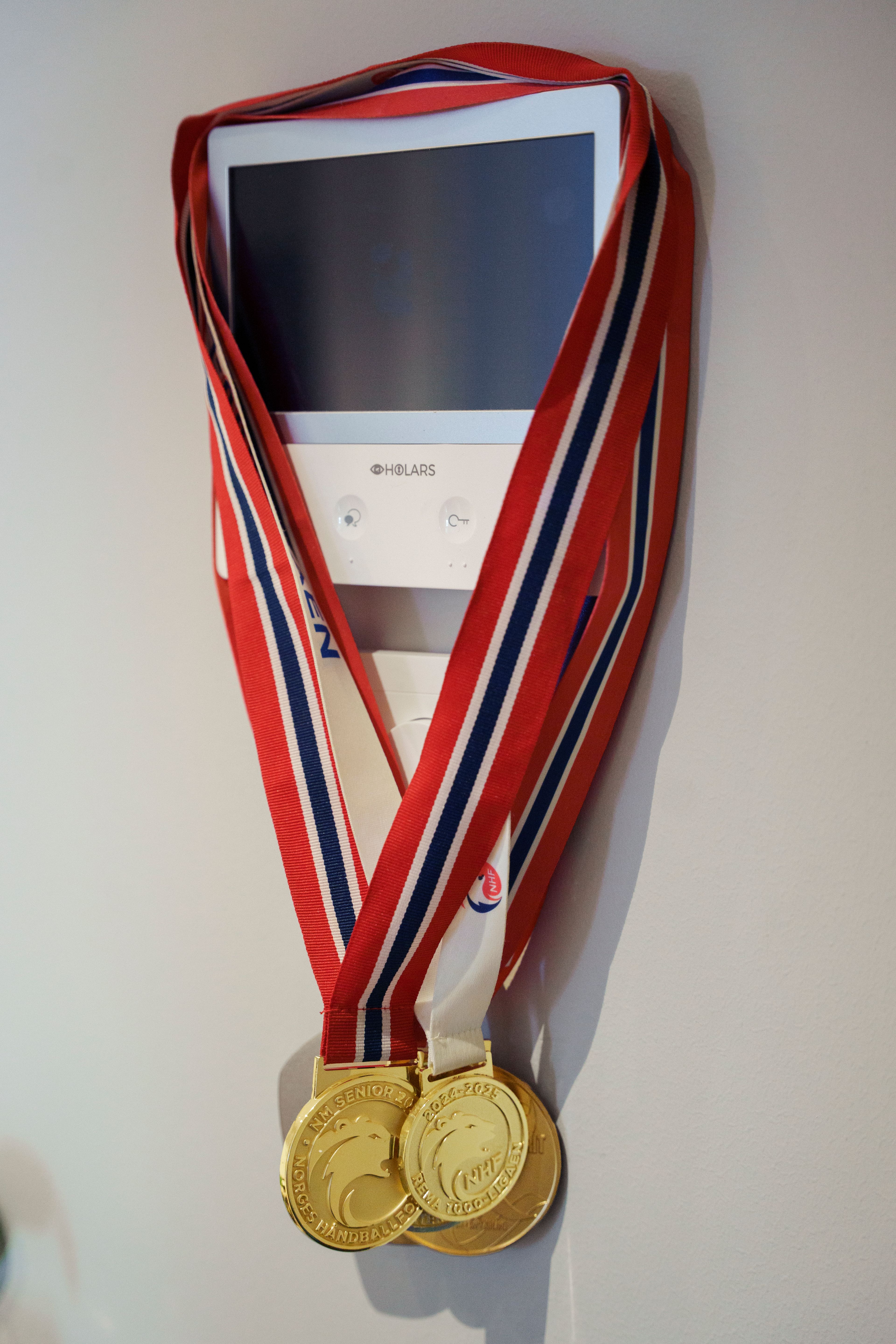 Nærbilde av medaljer som henger på et veggapparat