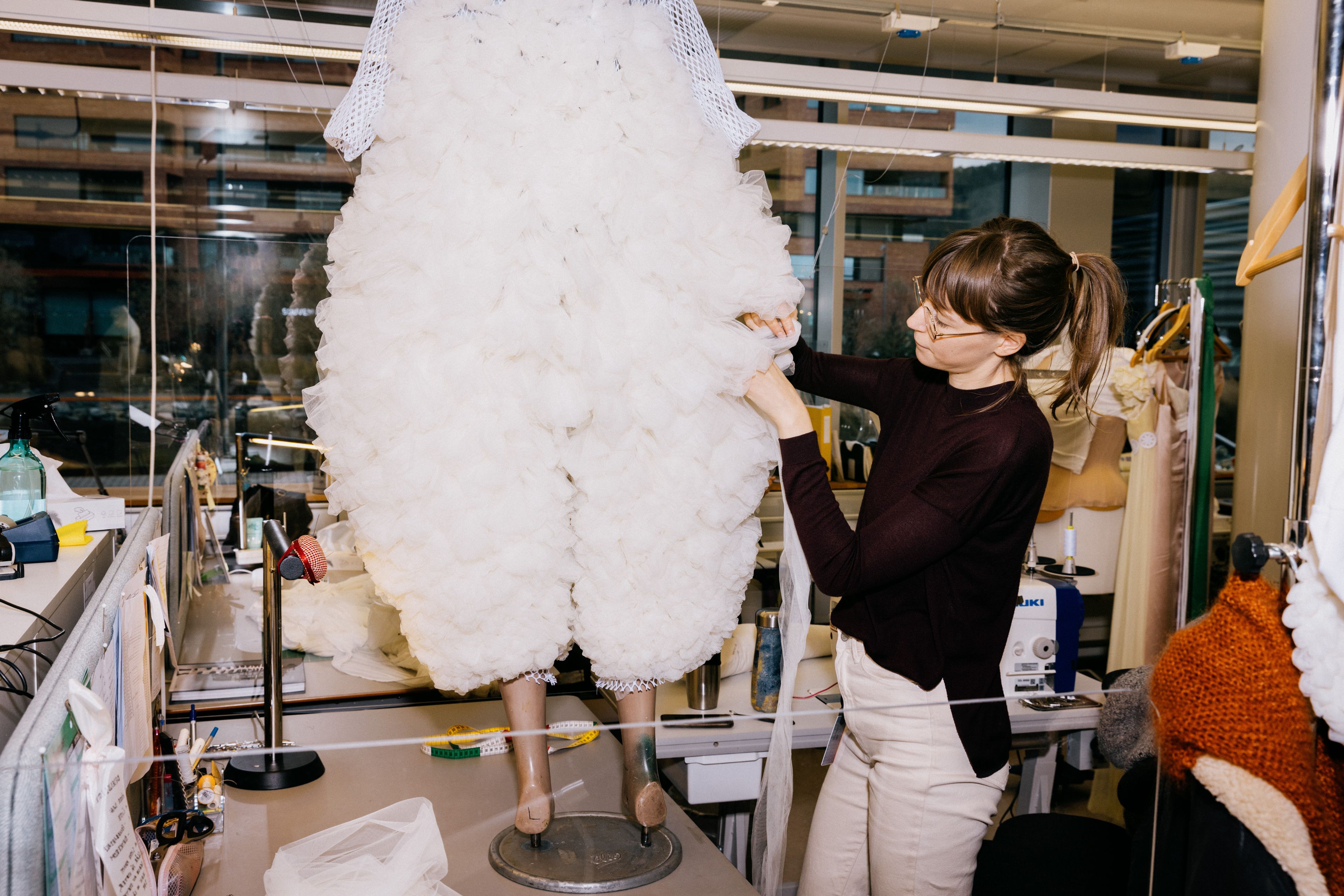 Bildet viser en dame som finpusser på deler av et kostyme til Orfeus i underverdenen.