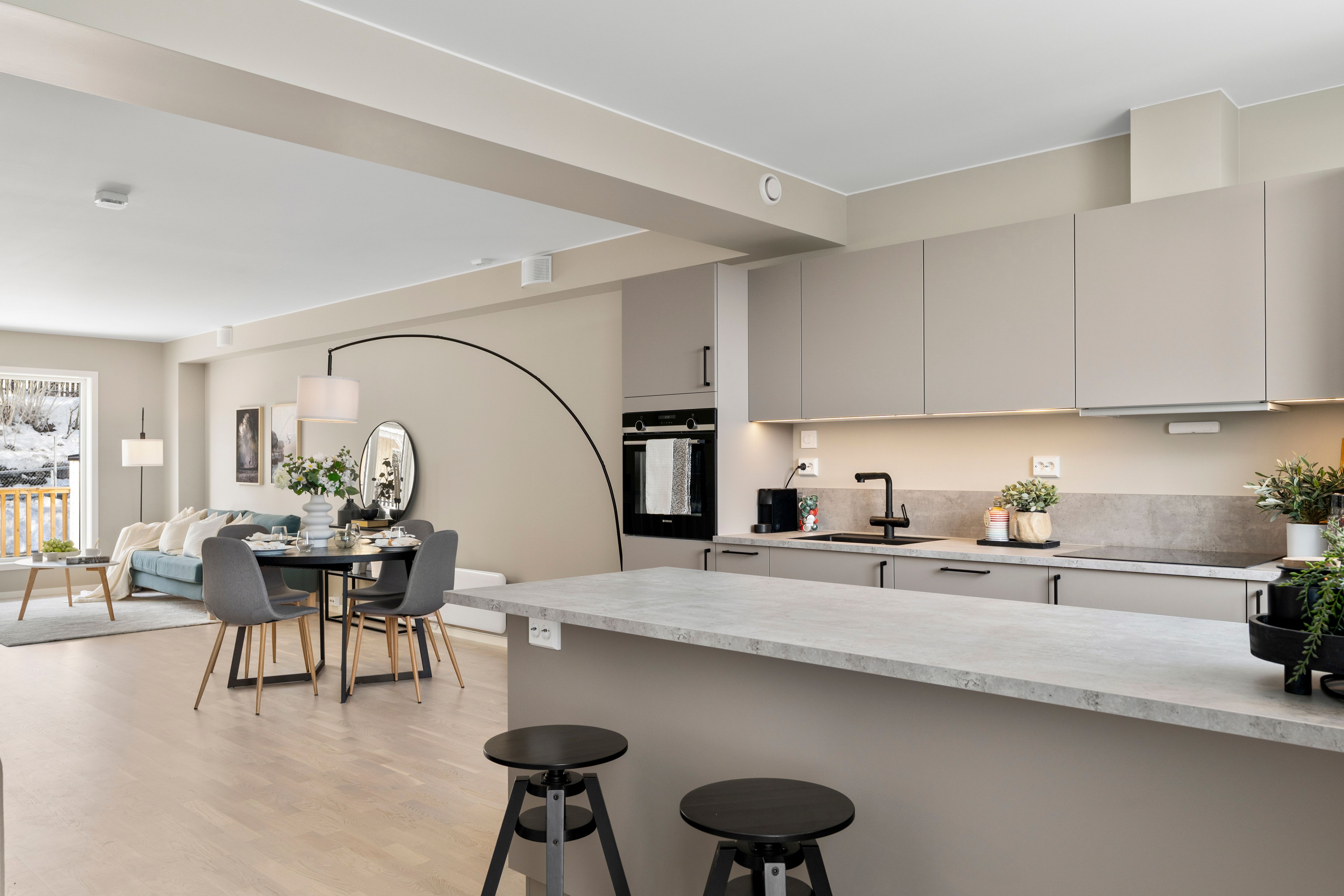 Bilde av åpen løsning med kjøkken, stue og spisestue i rekkehus (Hovedhuset) i Nedre Stavsetvegen 46.