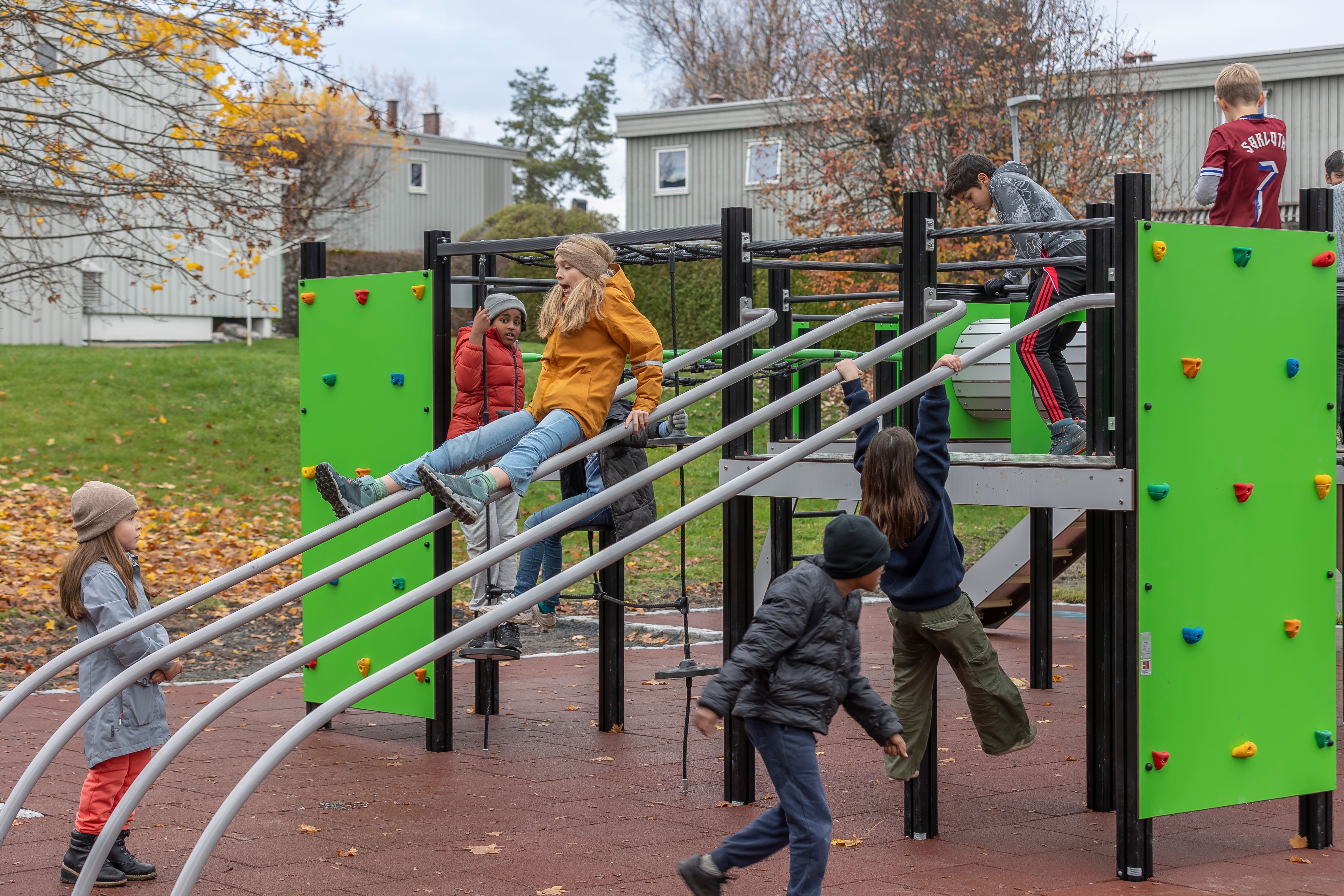Barn som leker i et klatrestativ på en lekeplass