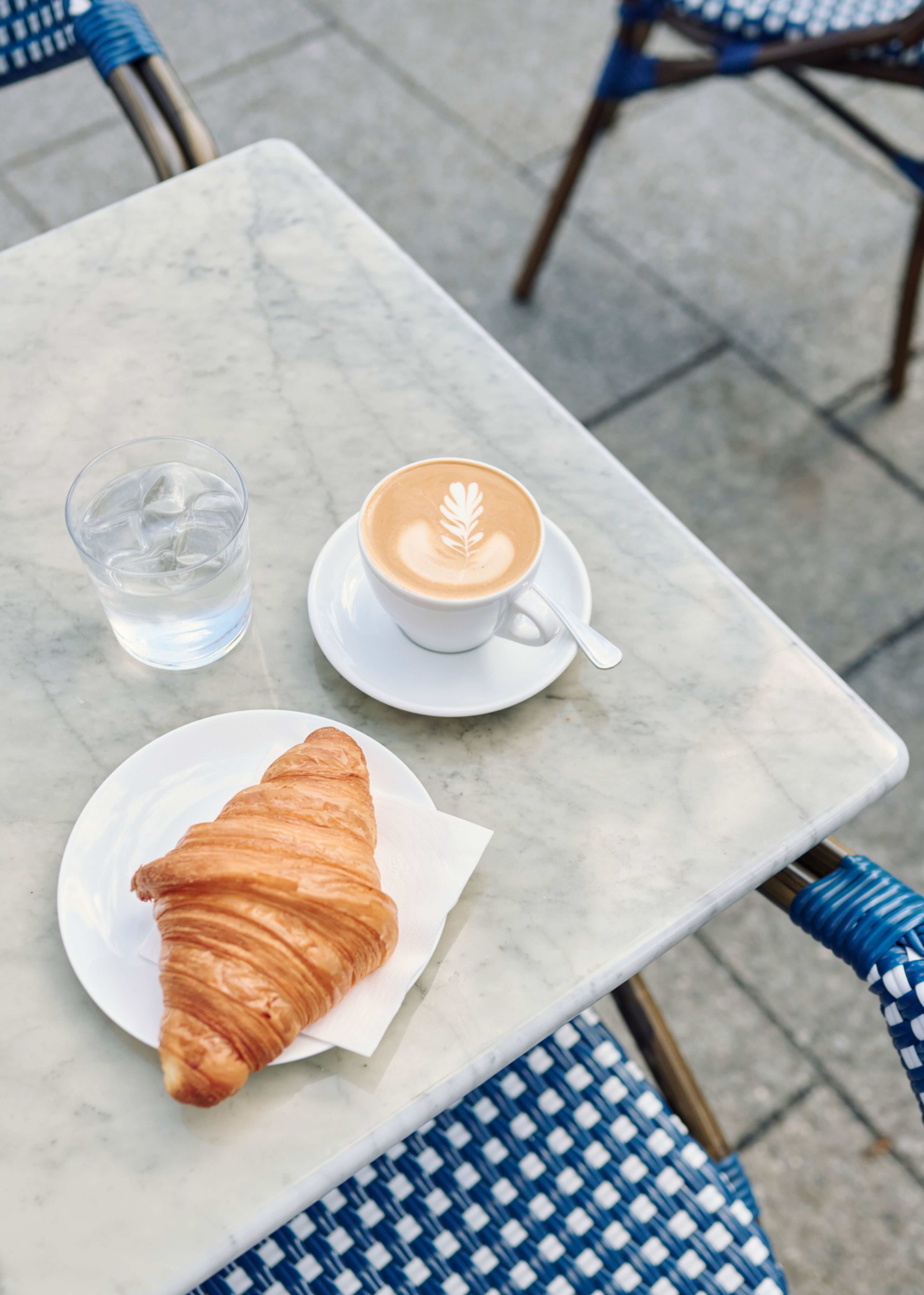 Et bord med bakevarer og kaffe på uteserveringen til Grains på Frysja.
