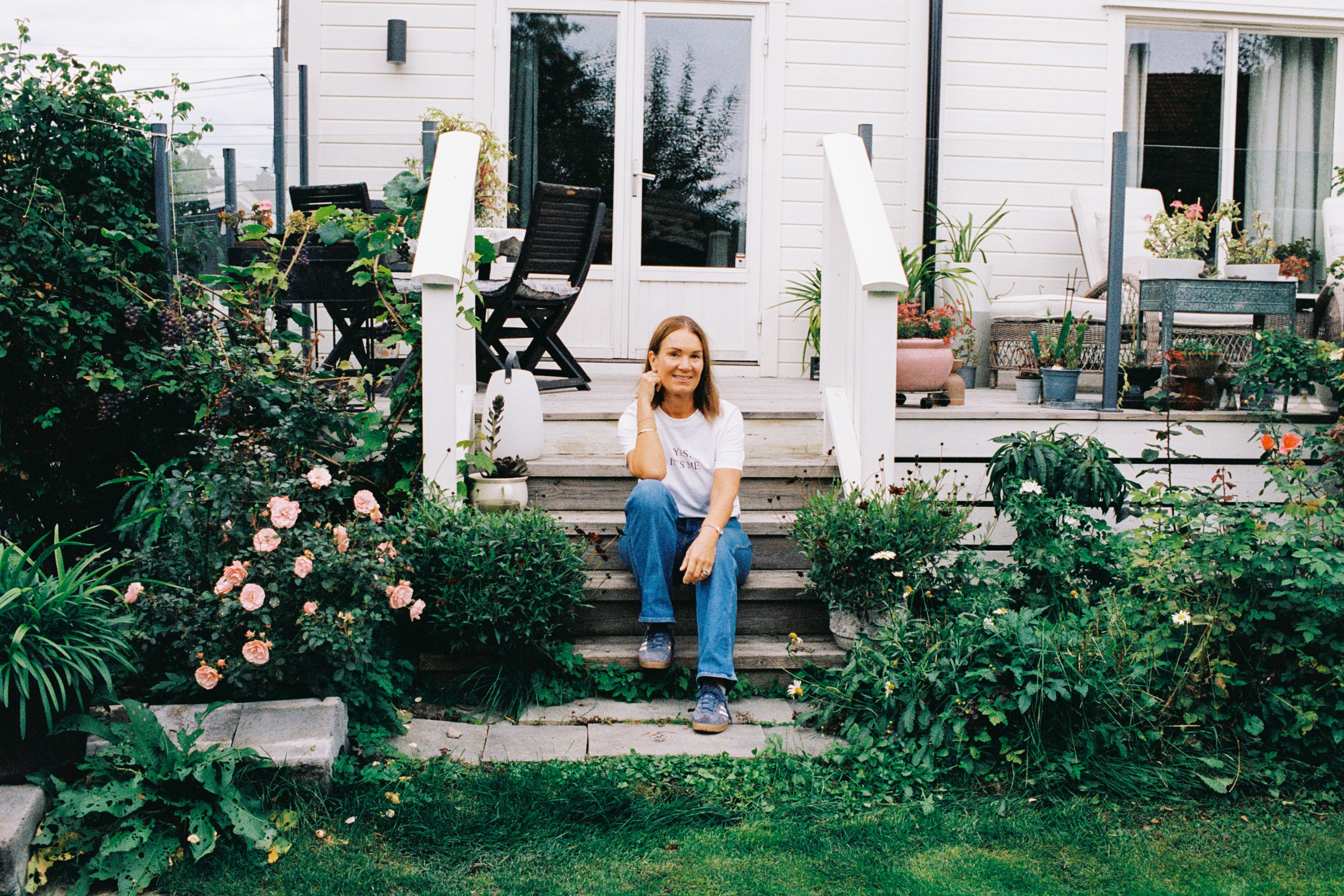 Camilla som sitter på trappen til hjemmet sitt.