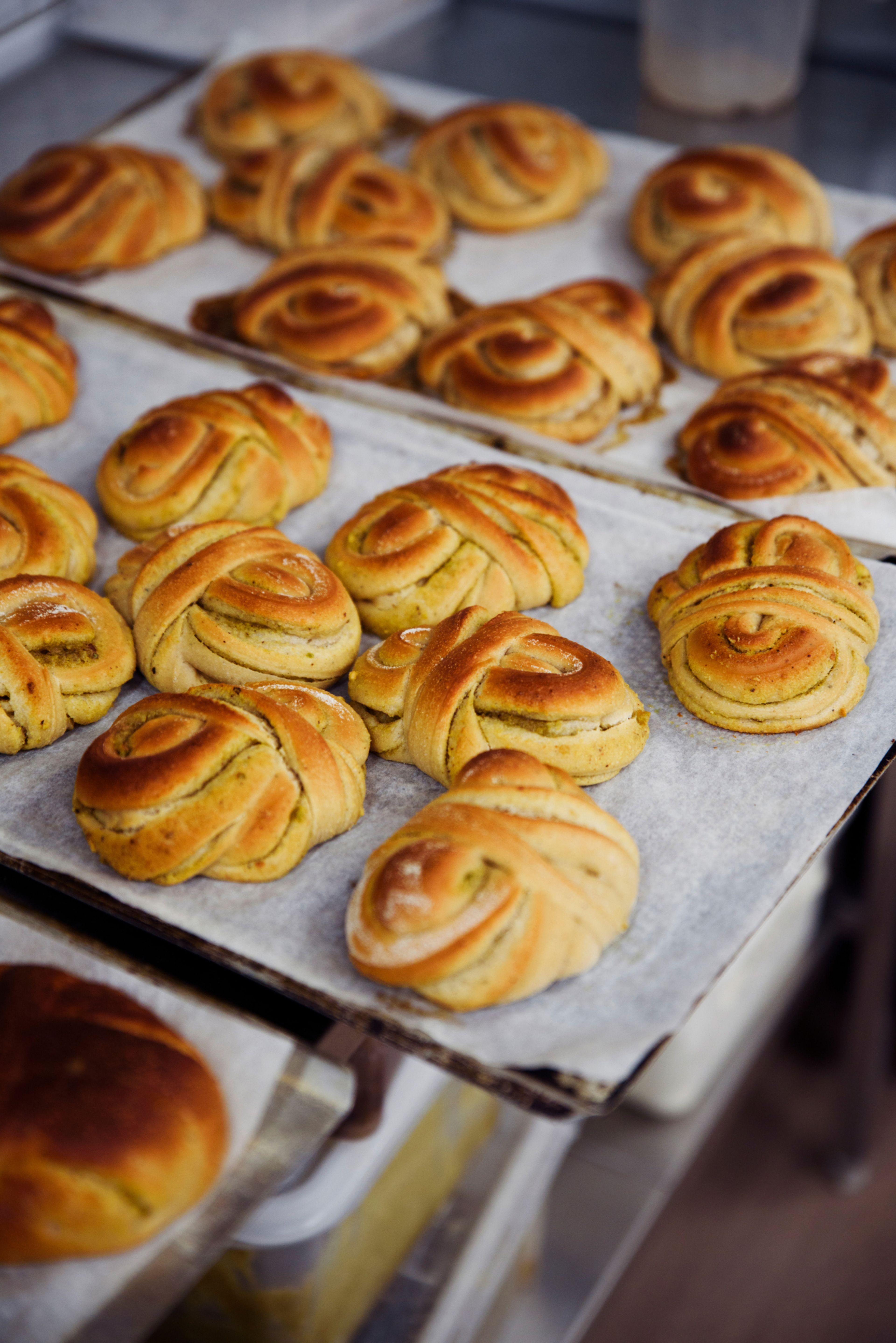 Bilde av tre stekebrett med kanelsnurrer på