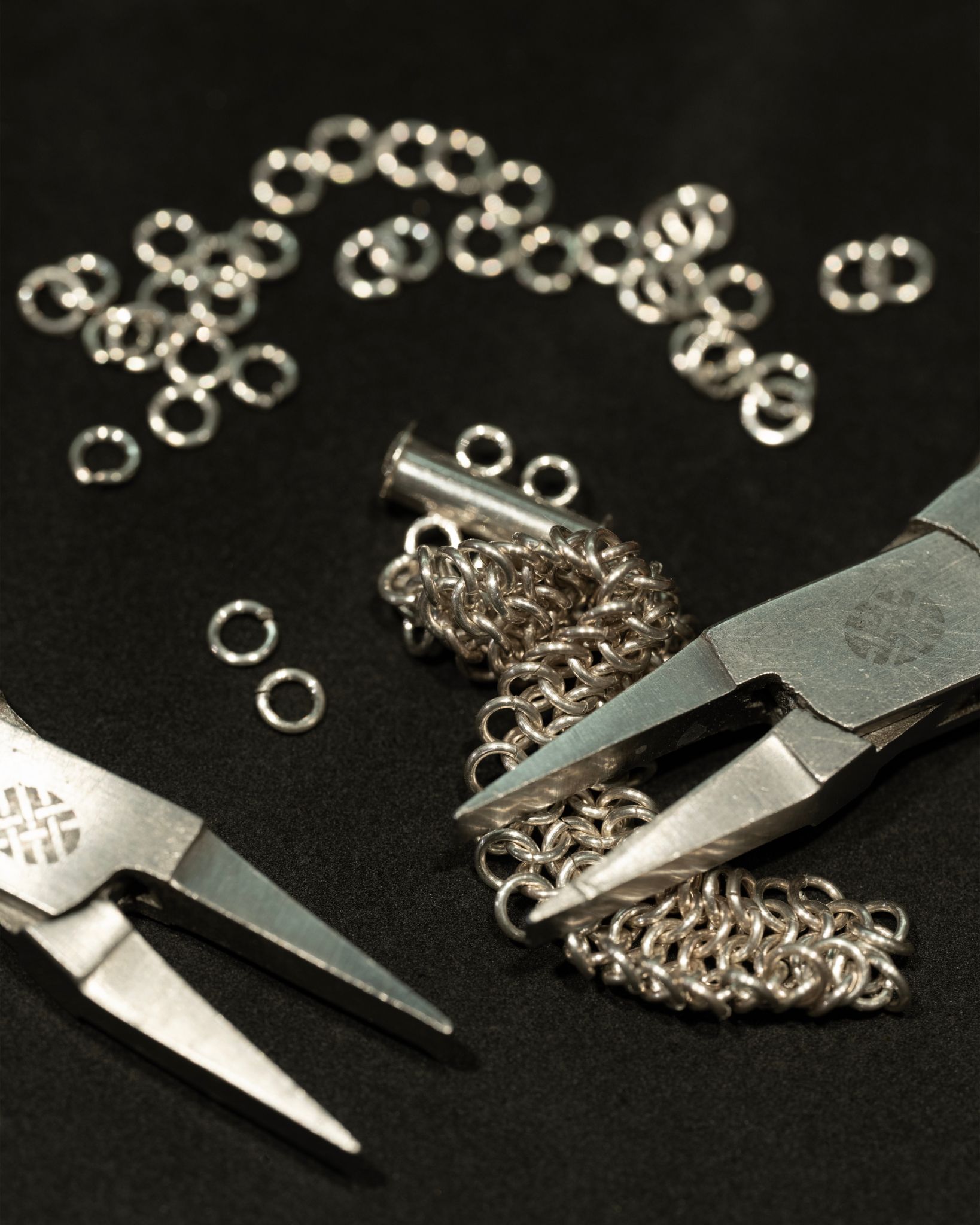 Foto av to tenger og et smykke i sølv.