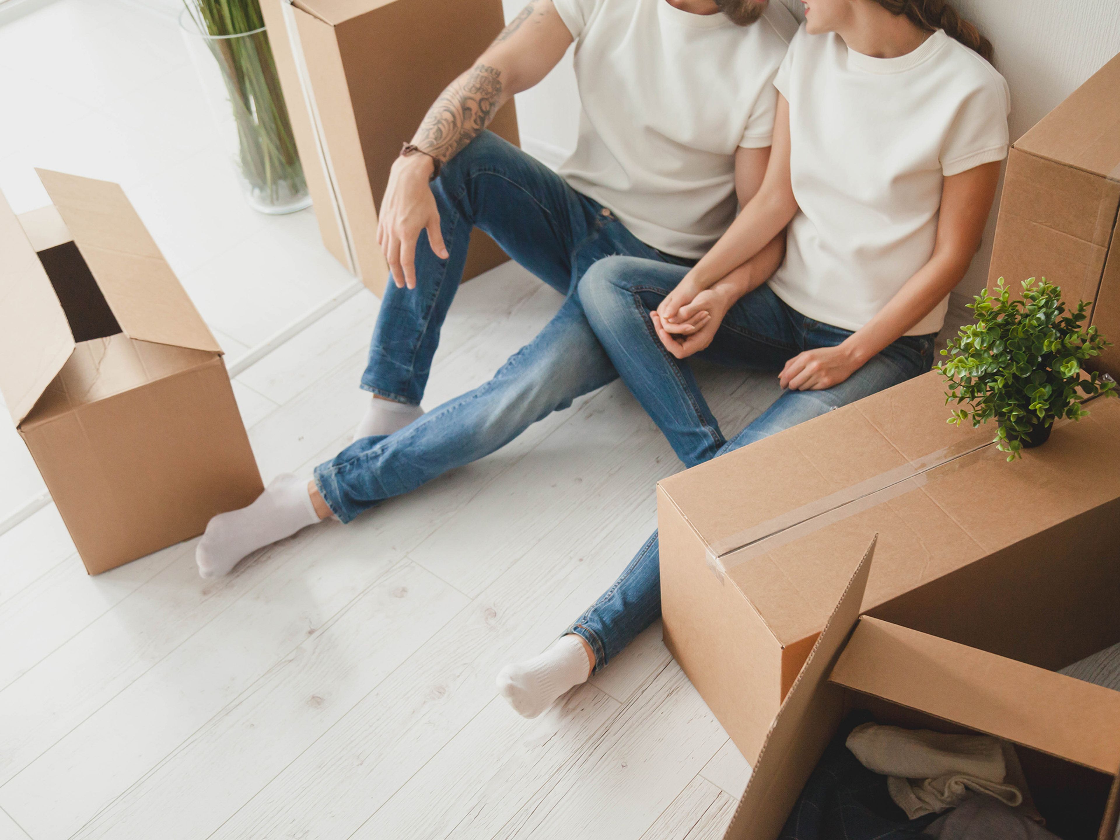 Ett par sitter bland flyttkartonger