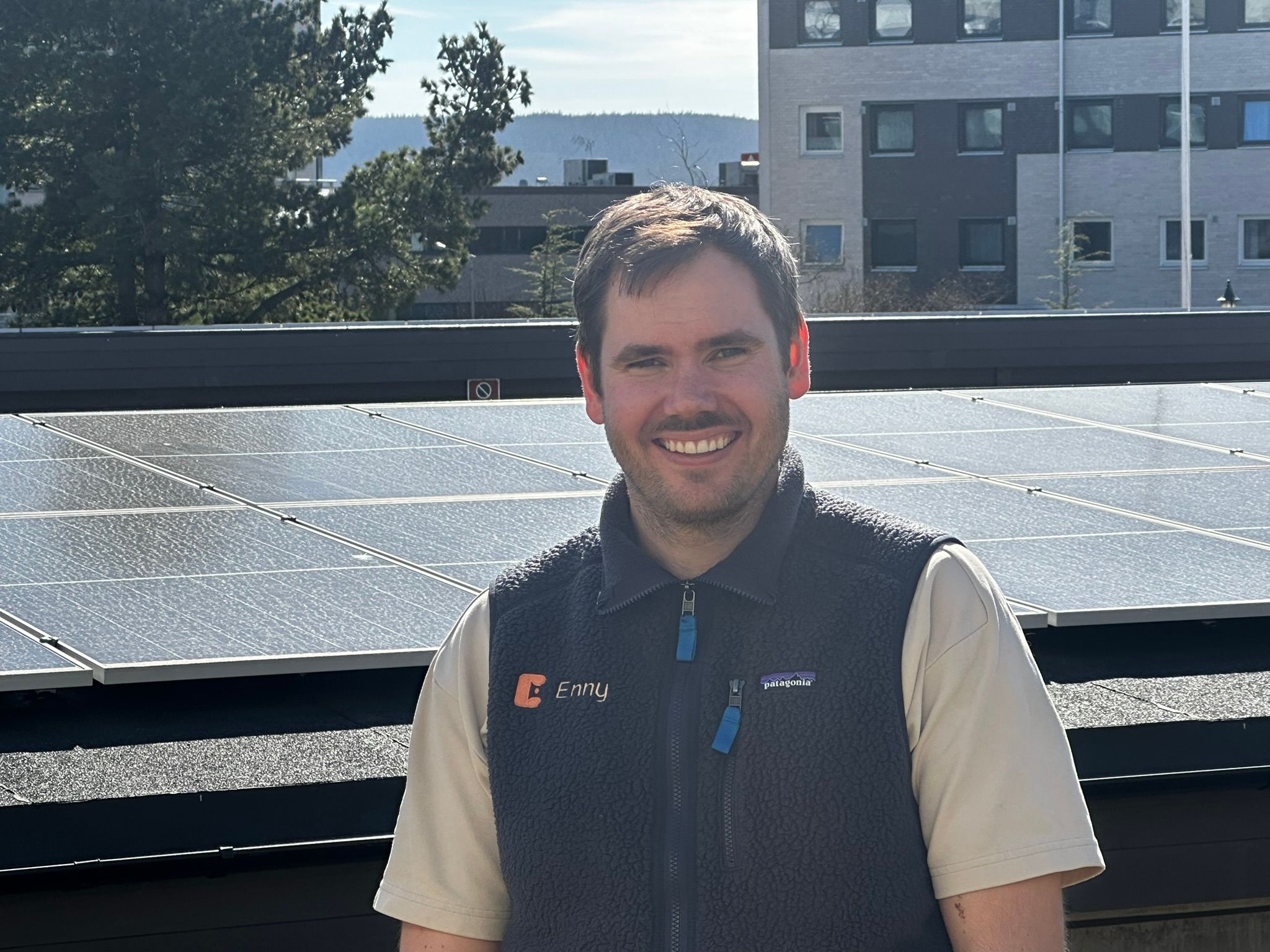 Ansatt i Enny står foran et tak med solceller