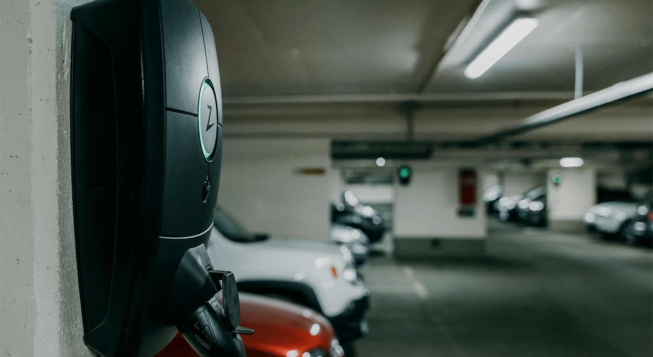 Elbillader i parkeringsanlegget til Sandaker borettslaget. I bakgrunnen ser vi parkerte biler.