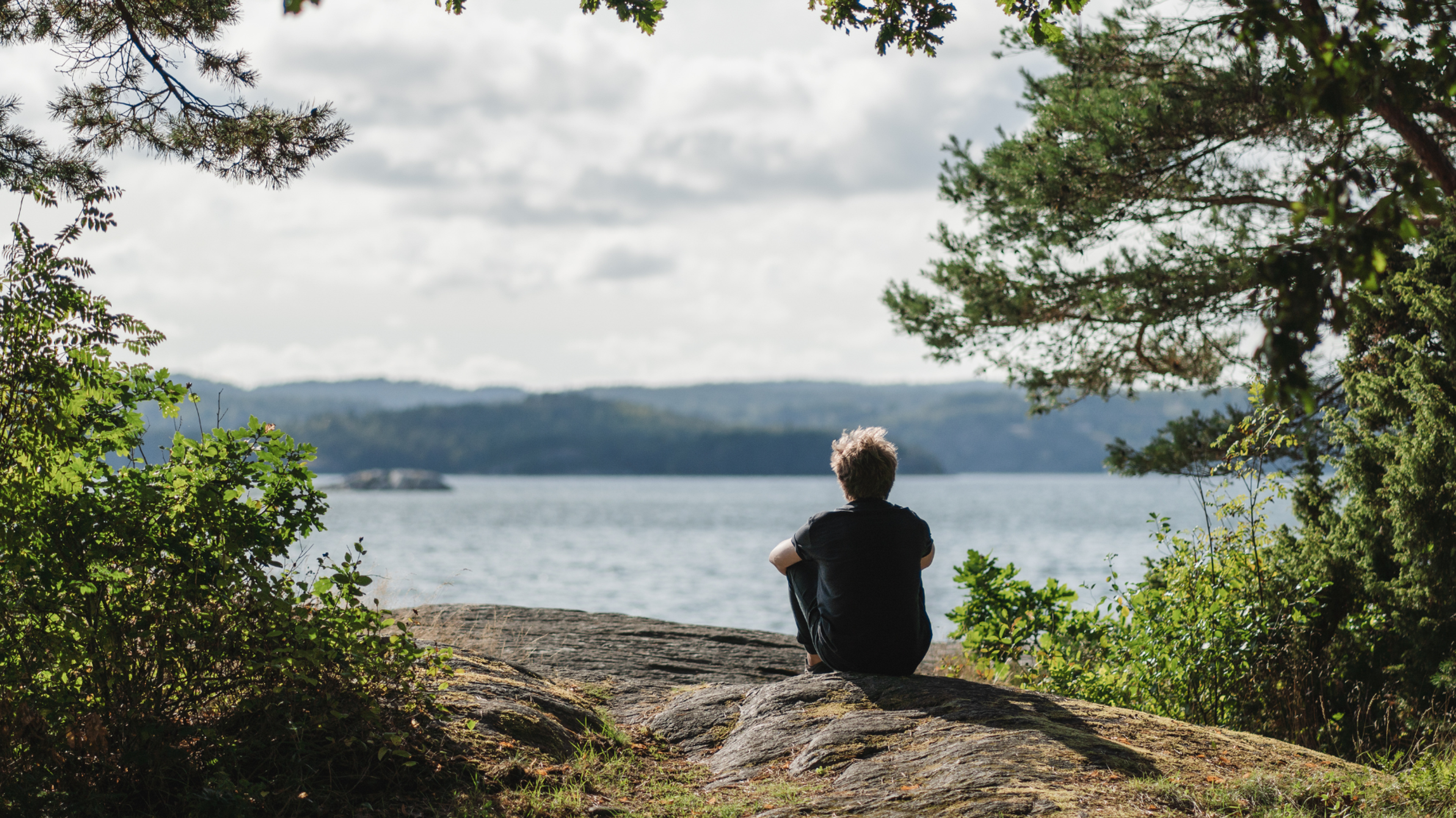 kille som sitter och tittar ut över vatten