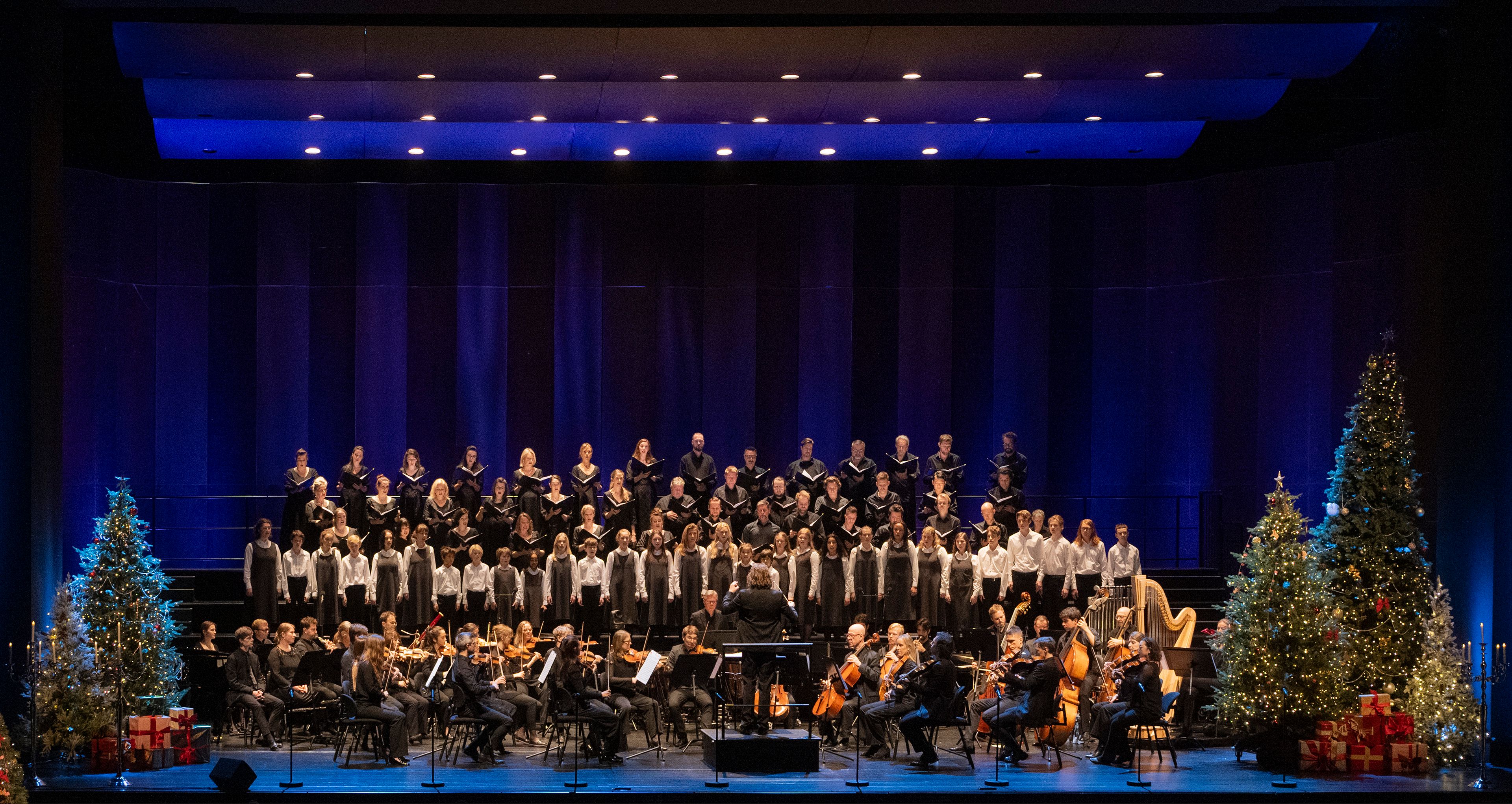 Foto av scenen under Julegalla med kor, orkester, dirigent og sanger i julestemning.