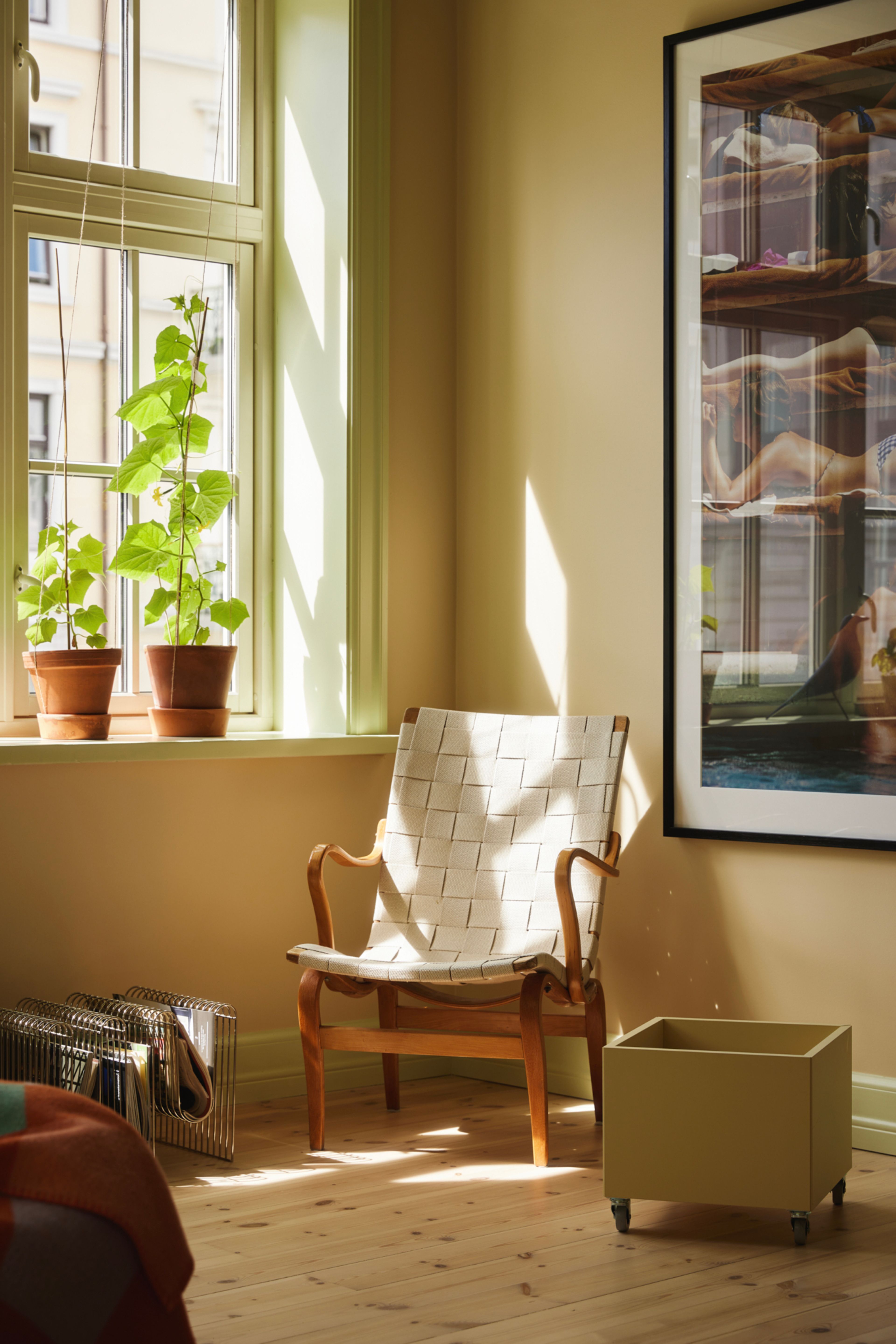 En Bruno Mathsson-stol står i hjørnet av stua og soler seg i lyset fra vinduet.