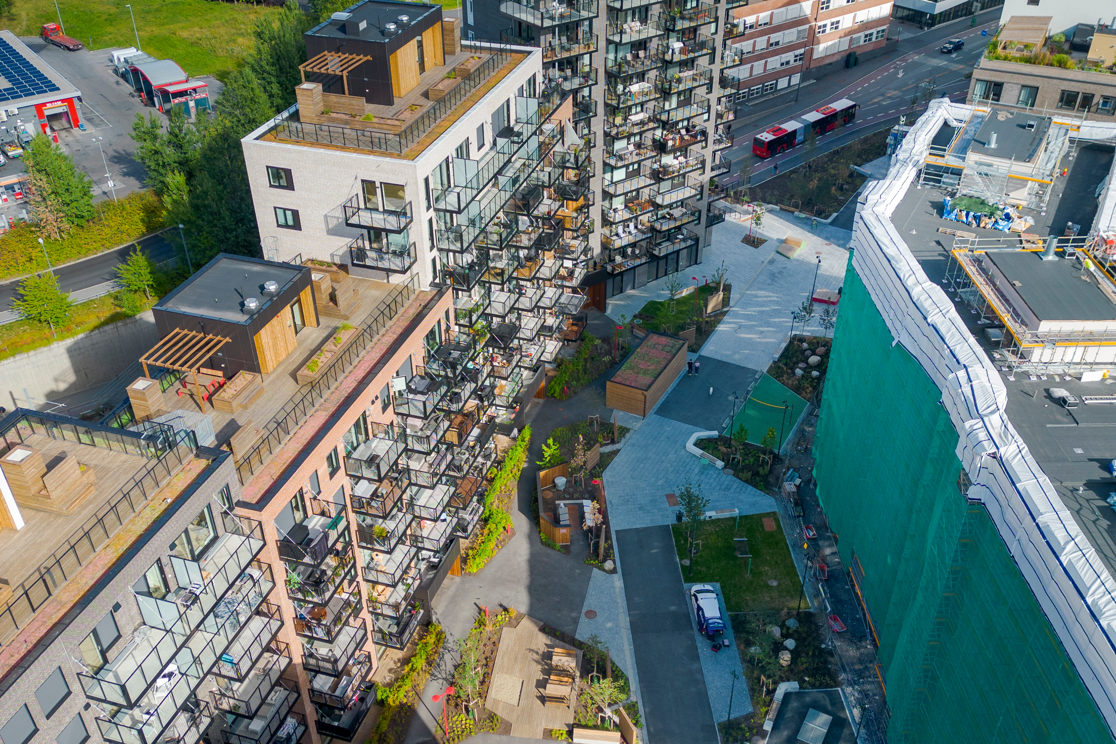 Dronefoto av et område med flere blokker. En av blokkene i bildet er under oppussing.