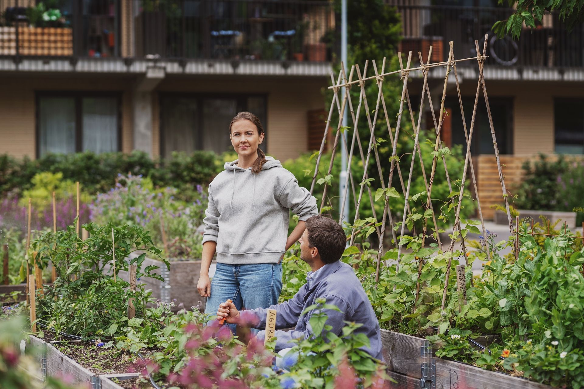 Kvinne og mann i et frodige uteområde i et borettslag.