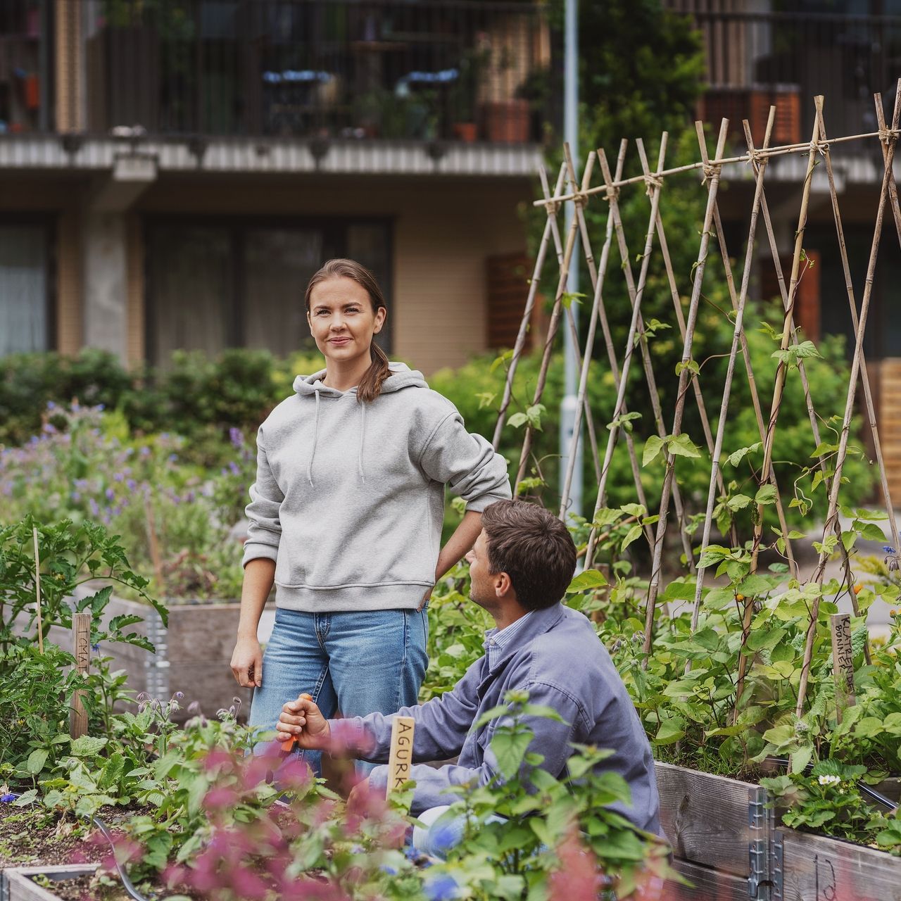Kvinne og mann i et frodige uteområde i et borettslag.
