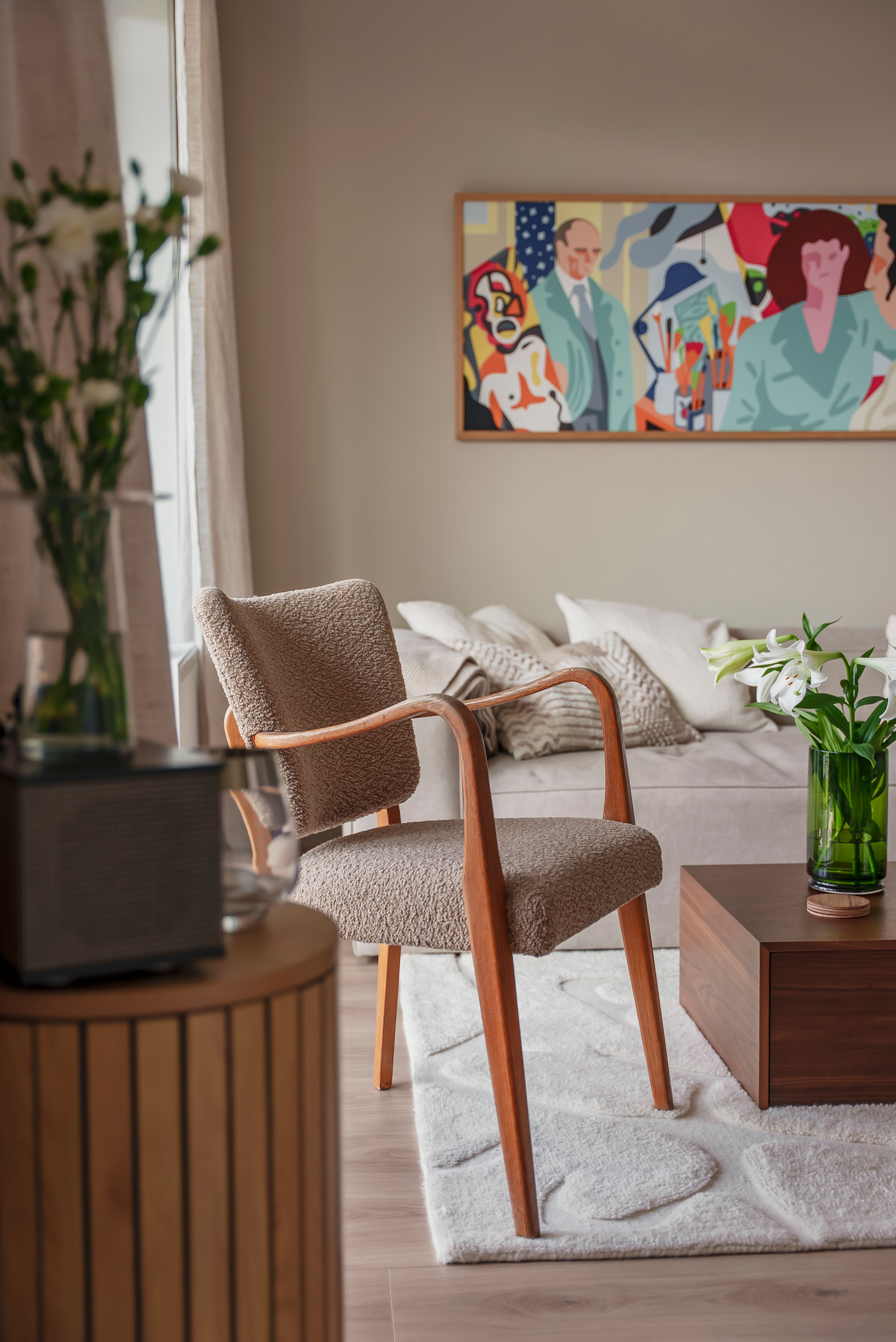 Stuen i duse og delikate farger, med et fargesterkt bilde som henger over sofaen.