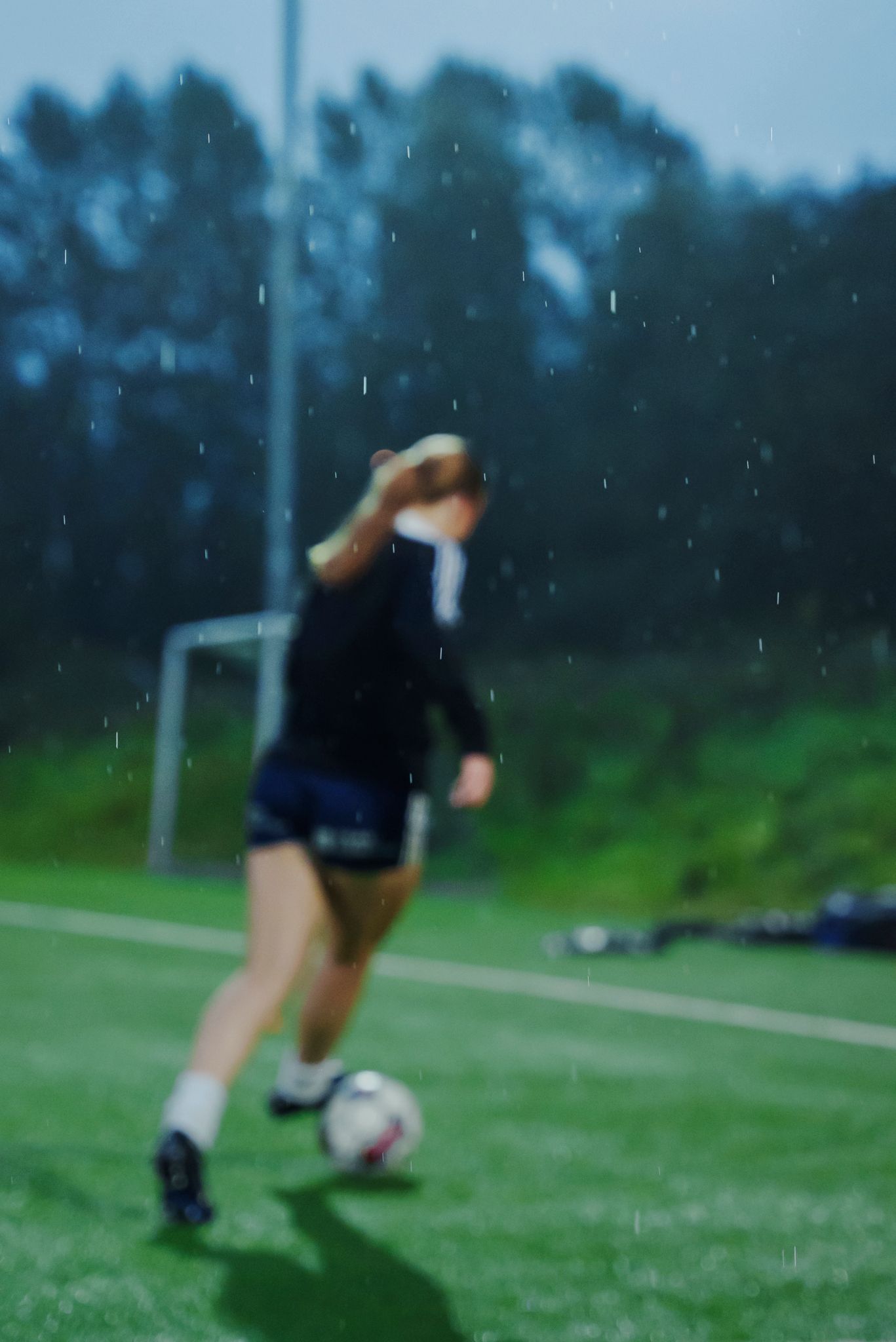 En UBK-spiller med ryggen til kamera fører ballen.