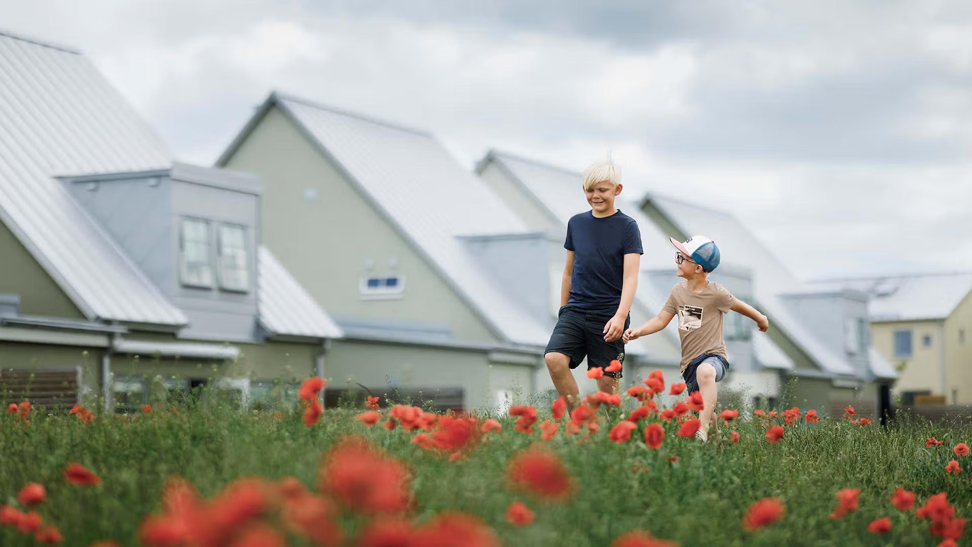 Bild på barn utanför nybyggda hus