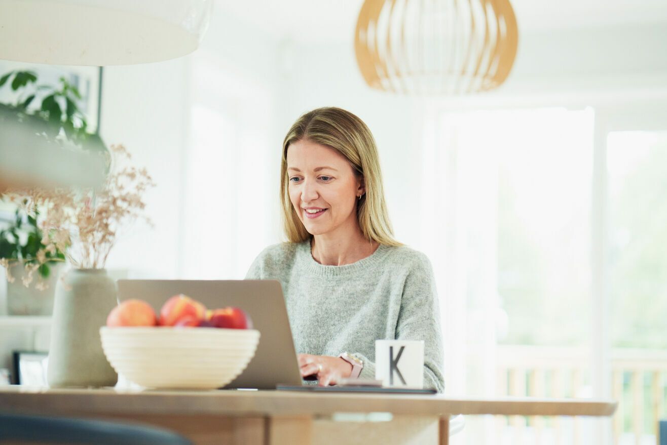 Forbrukerfrue sitter ved datamaskinen sin.
