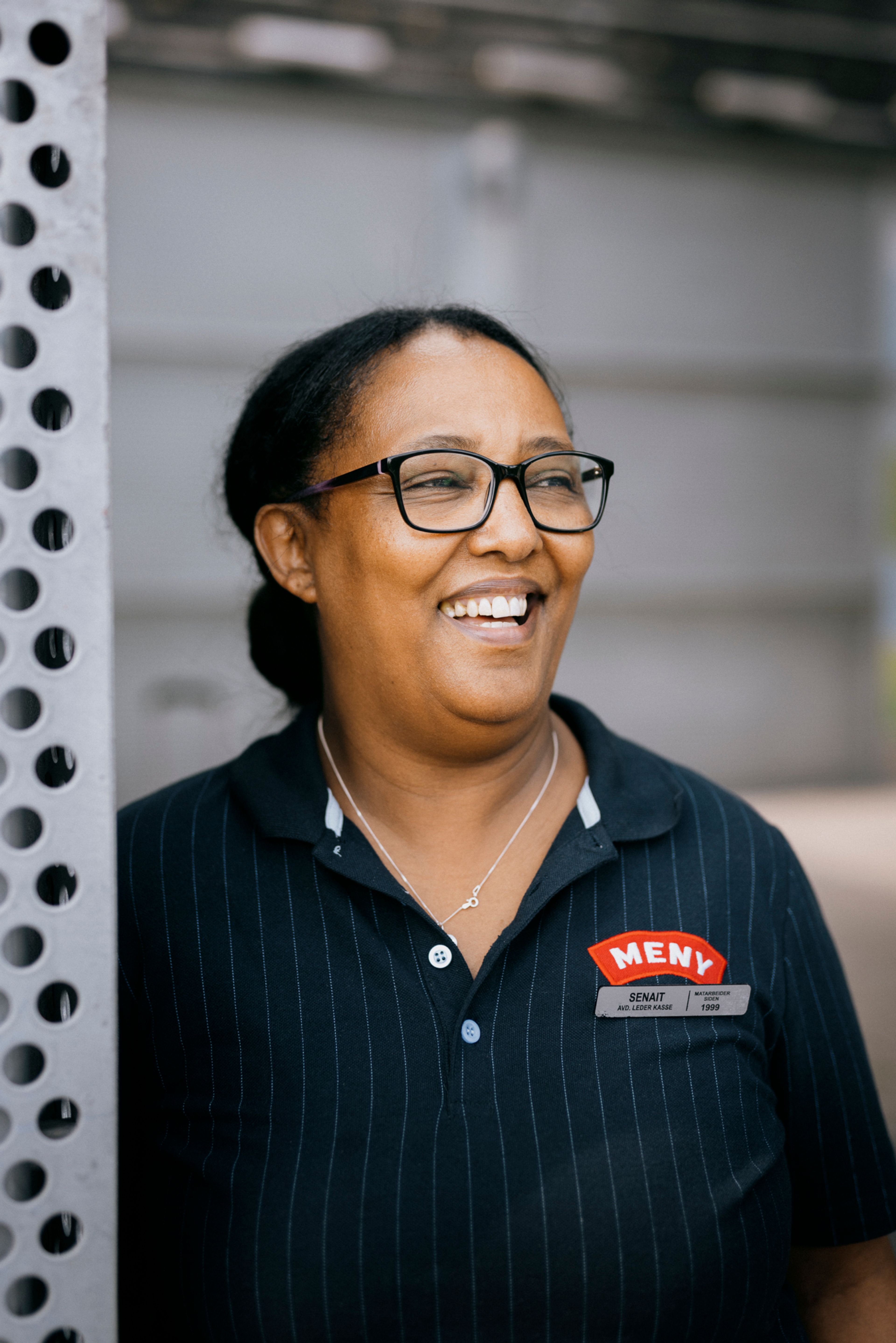 Nærbilde av Senait som smiler utenfor senteret.