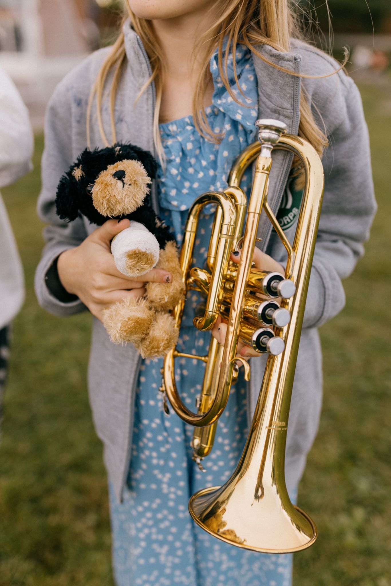 En ung musikant med instrumentet hennes og en bamse.