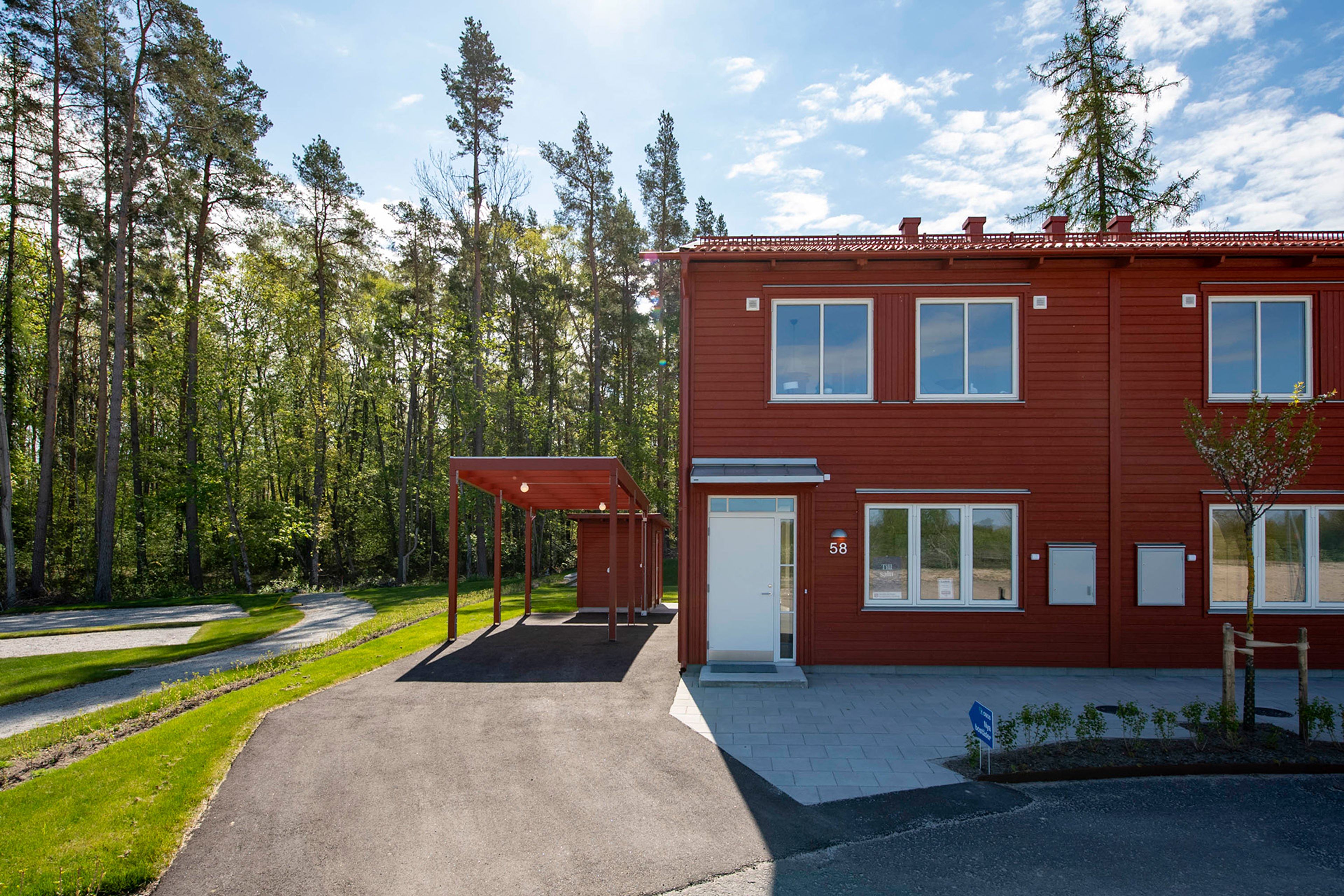 Exteriör parhus med röd fasad och vit ytterdörr