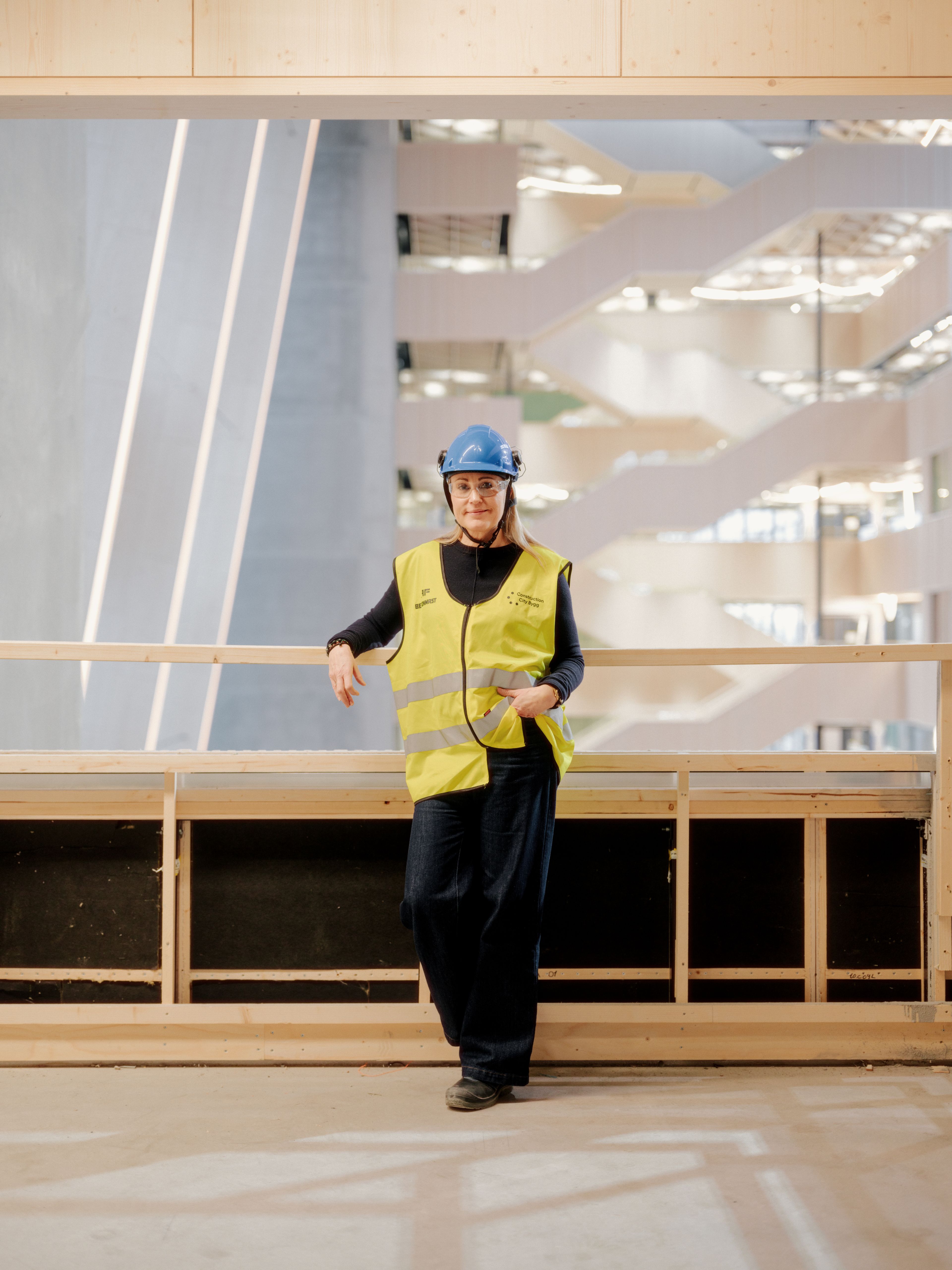 Portrettbilde av Elin Schjenken Halvorsen som lener seg mot et gelender i bygget Construction City